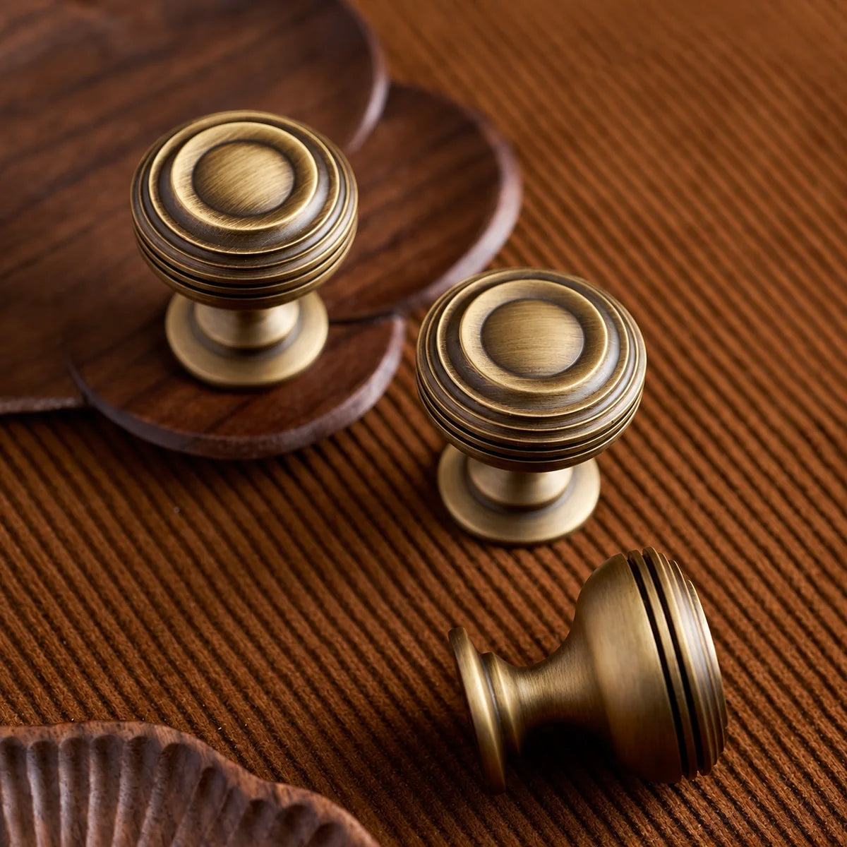 Ringed antique brass pedestal knobs showing face and side profile