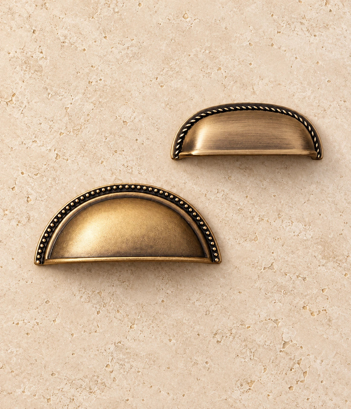 Antique Brass Rope-Edge & Deep Beaded Cup Pulls on warm limestone