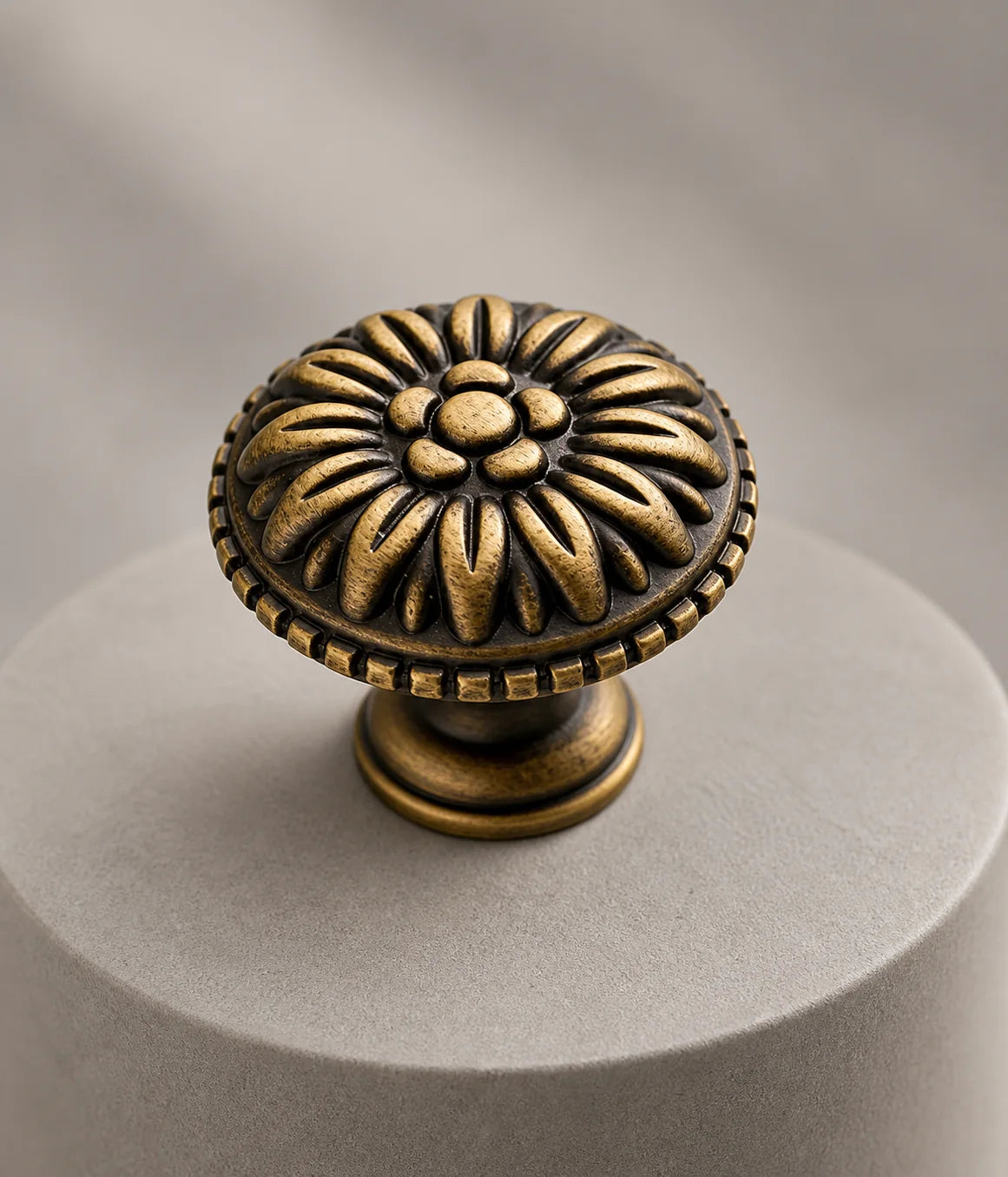 Close-up of the raised floral face and textured rim of an antique brass rosette knob