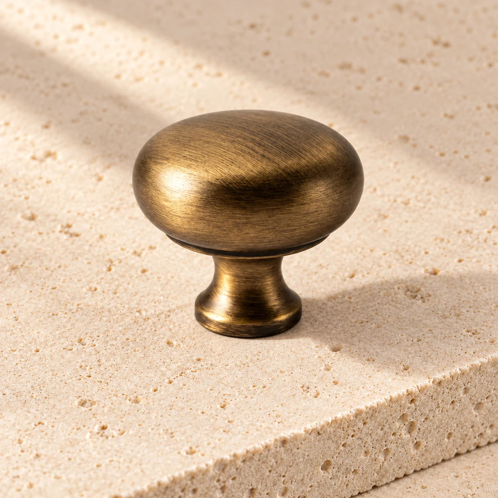 antique brass rounded cup knob limestone on pale limestone.