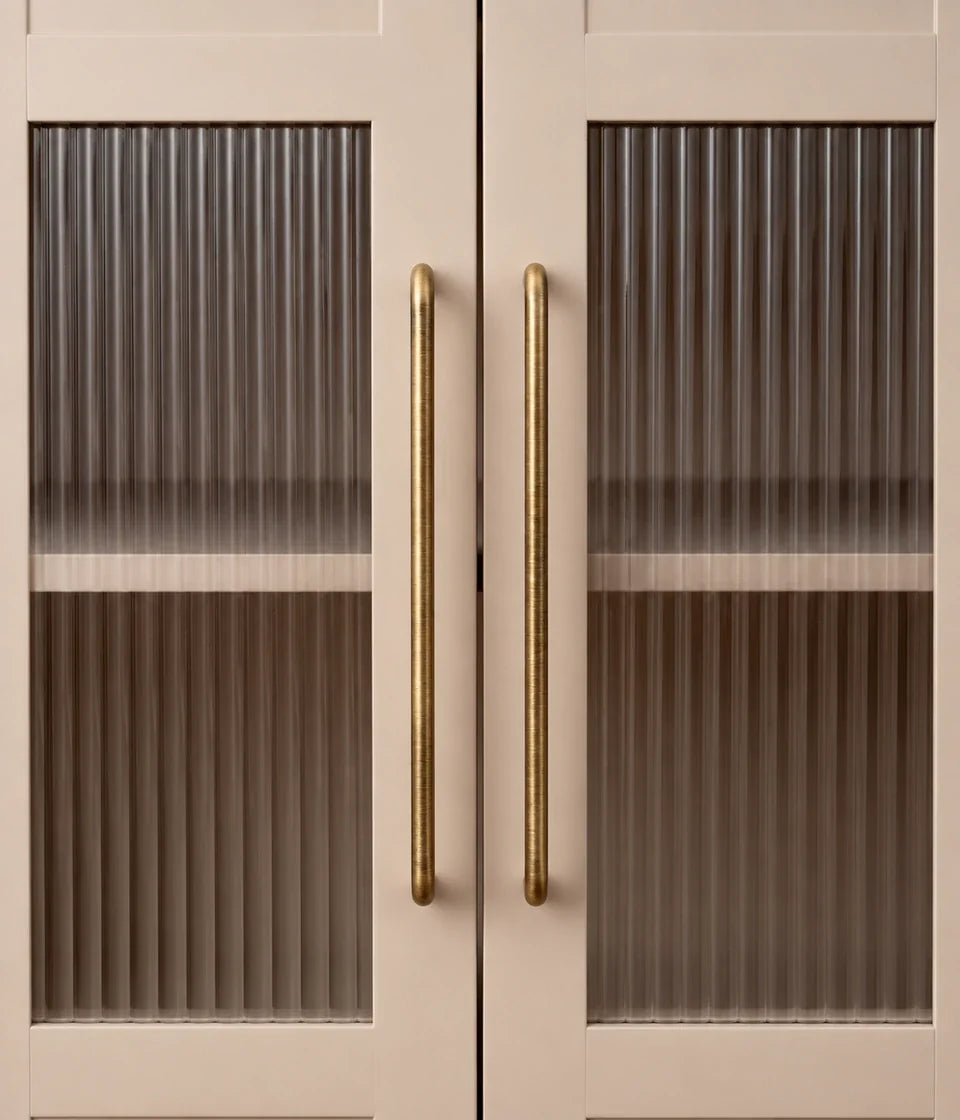 Rounded antique brass cabinet pulls installed on fluted glass doors