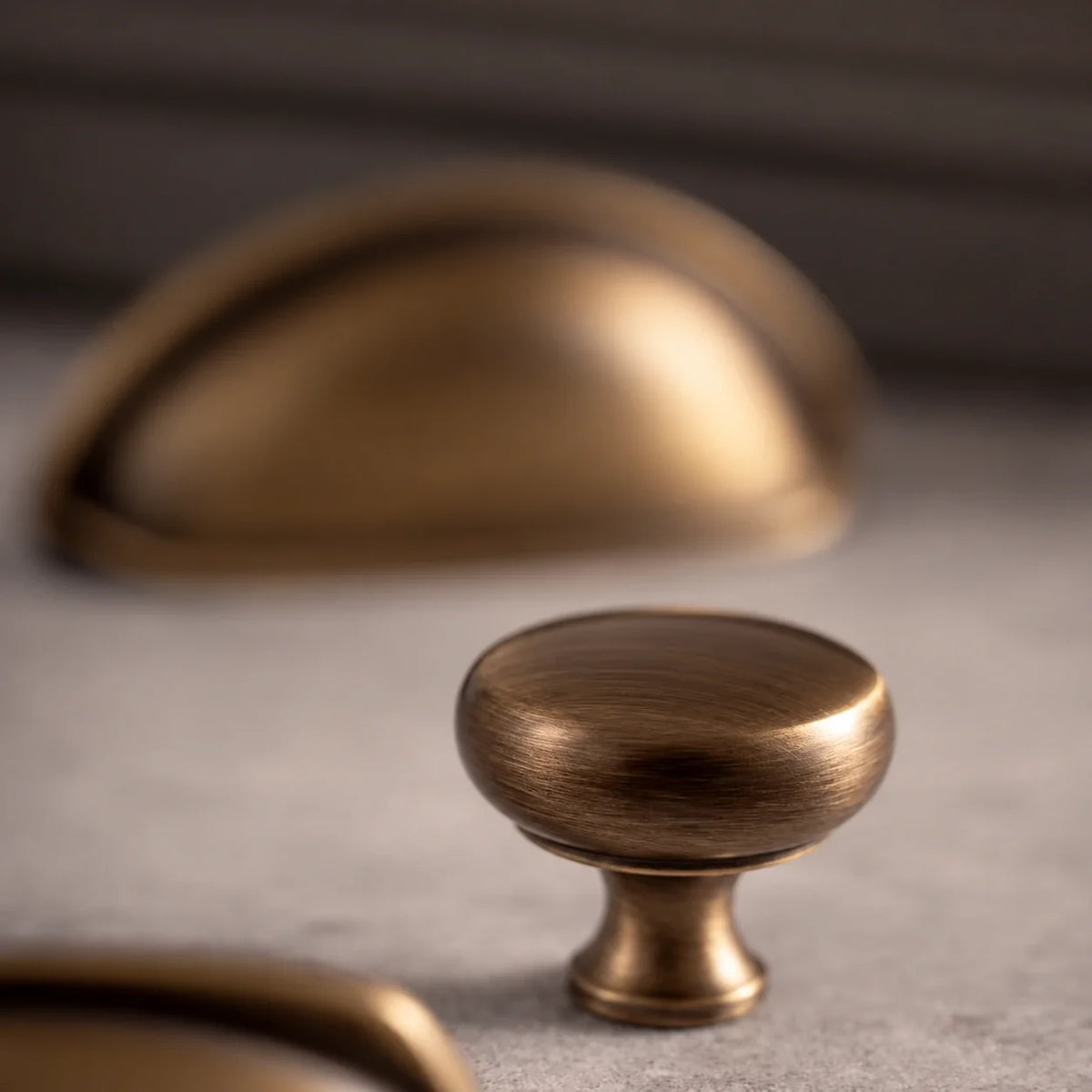 Close-up of a round antique brushed brass cabinet knob