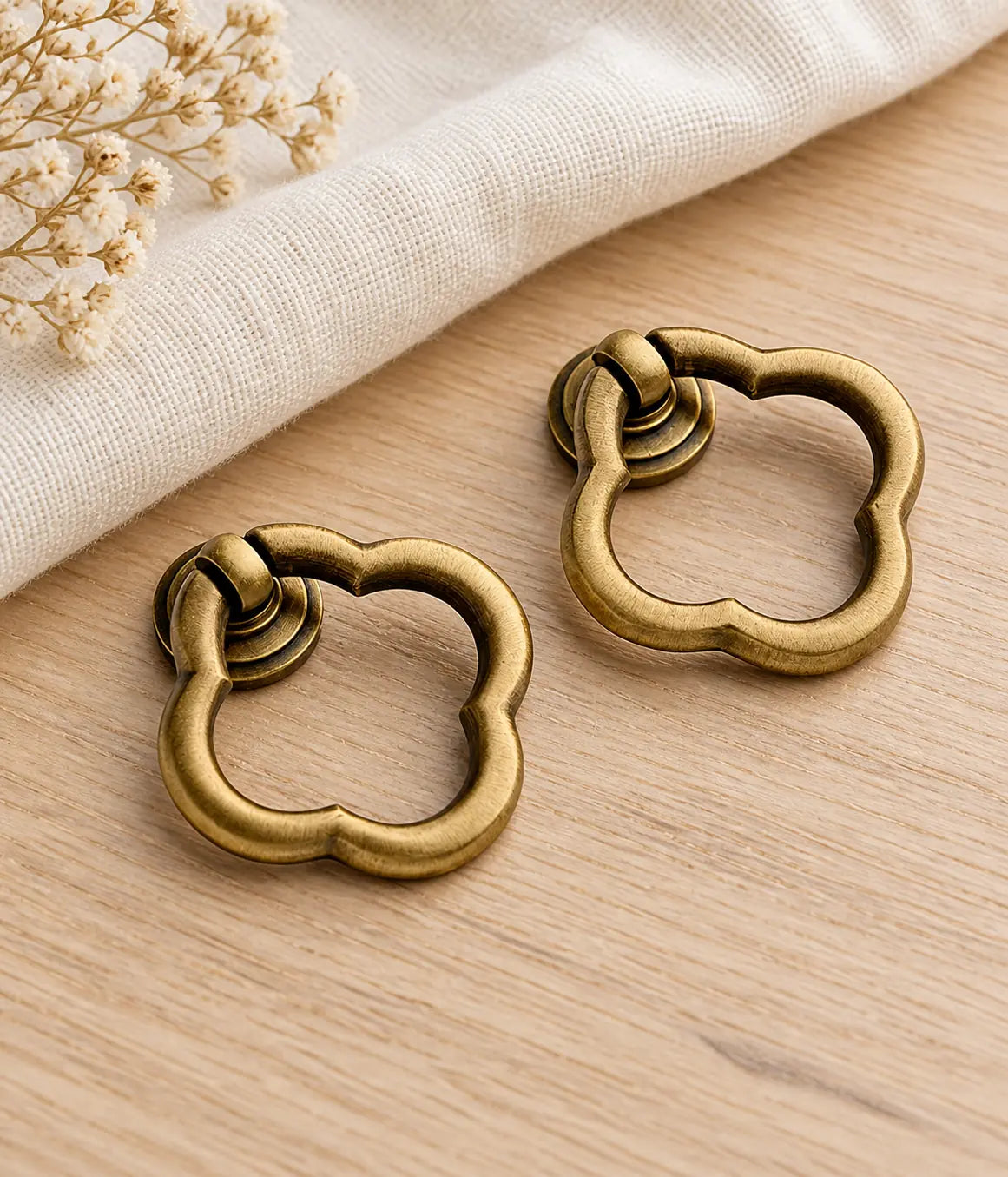 Scalloped antique brass ring pulls styled on pale oak and linen