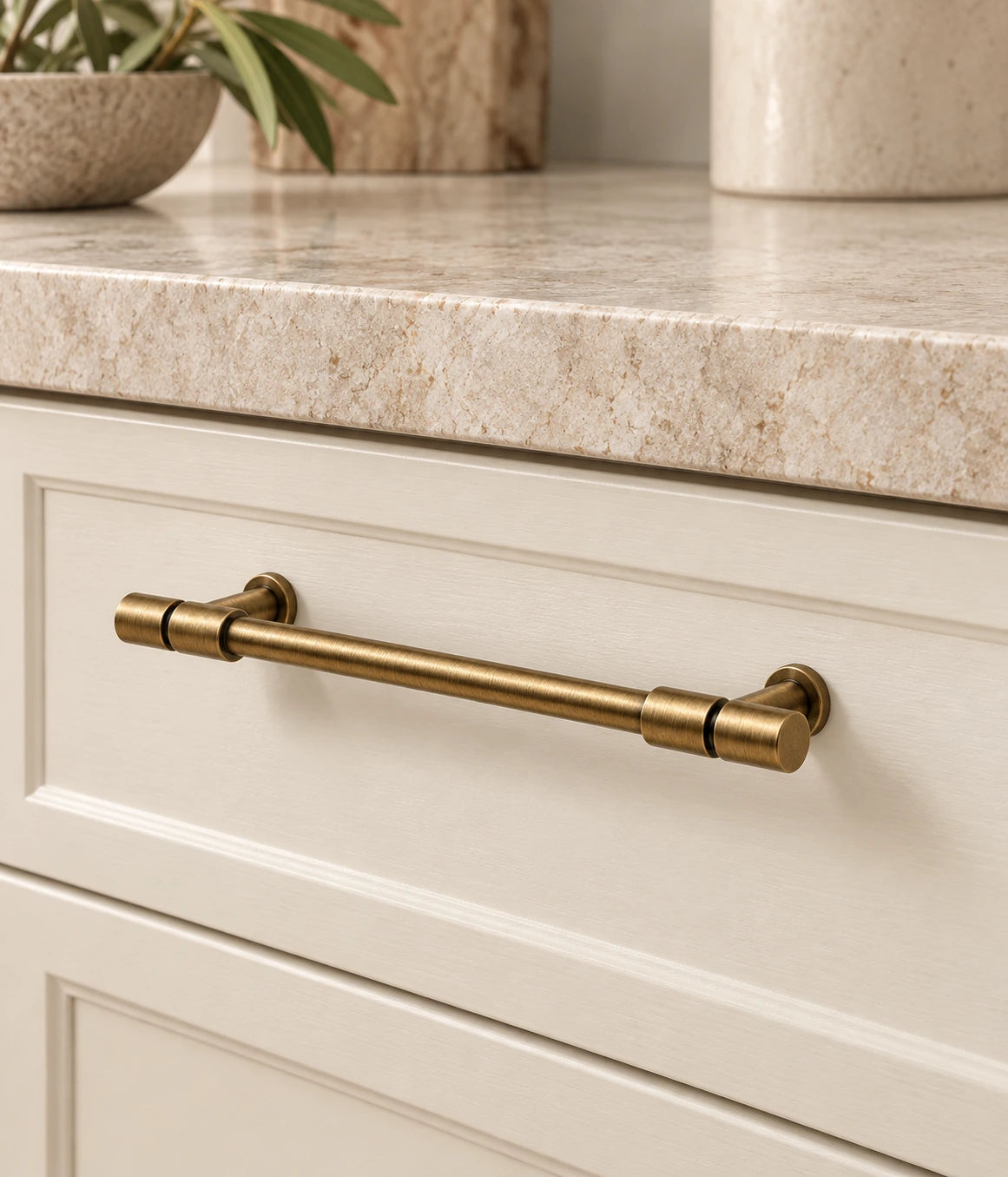 Antique Brass Segmented-End Cabinet Pulls & T-Knob installed on an ivory cabinet drawer