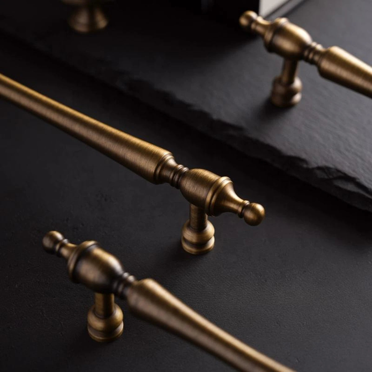 Close-up of narrow posts and turned finial ends on solid brass cabinet pulls