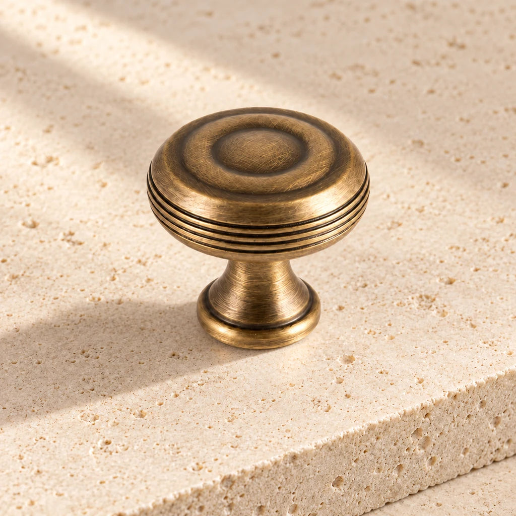 antique brass slender finial grooved knob limestone on pale limestone.