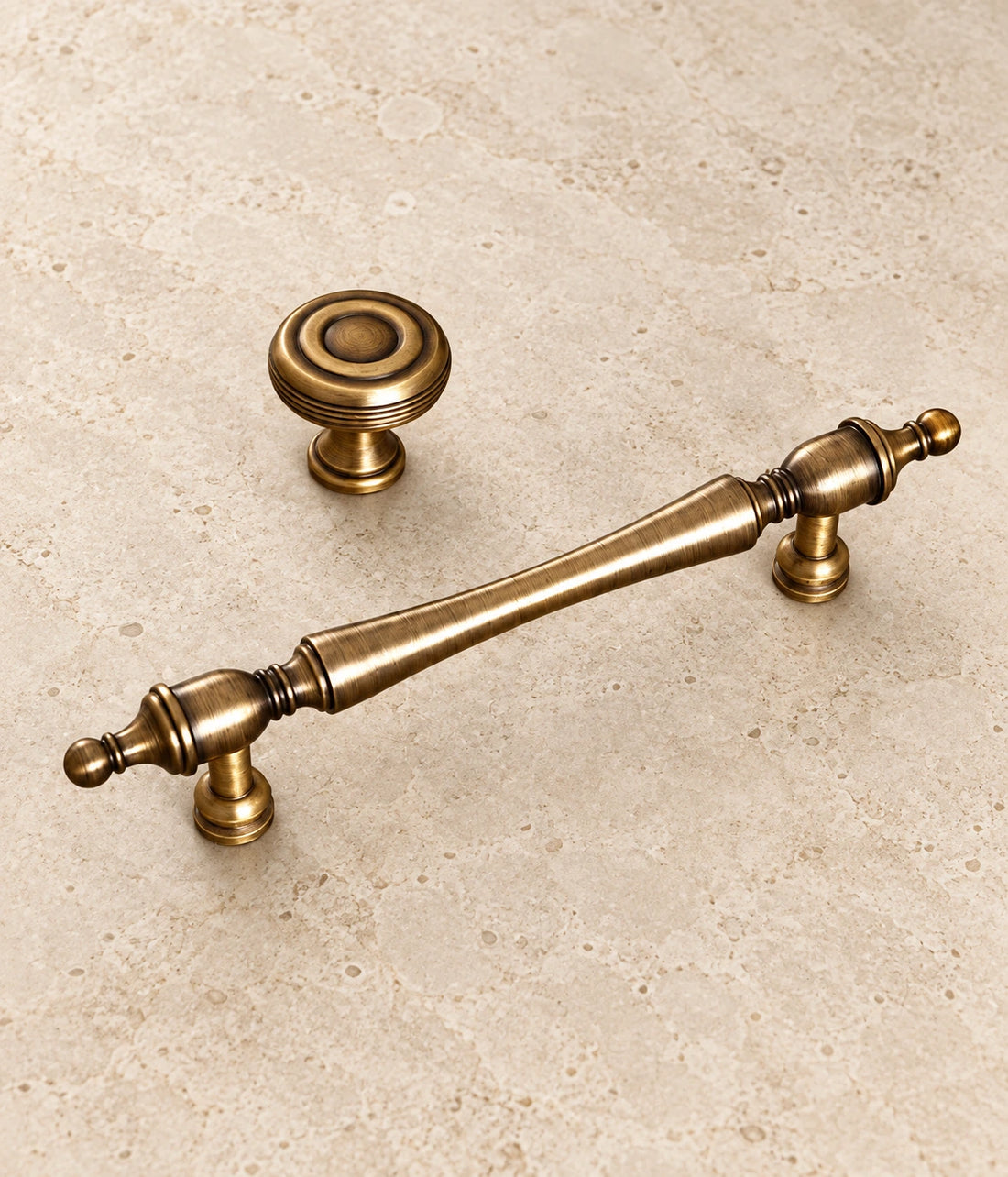 Antique Brass Slender Finial Pulls & Grooved Knobs on warm ivory limestone