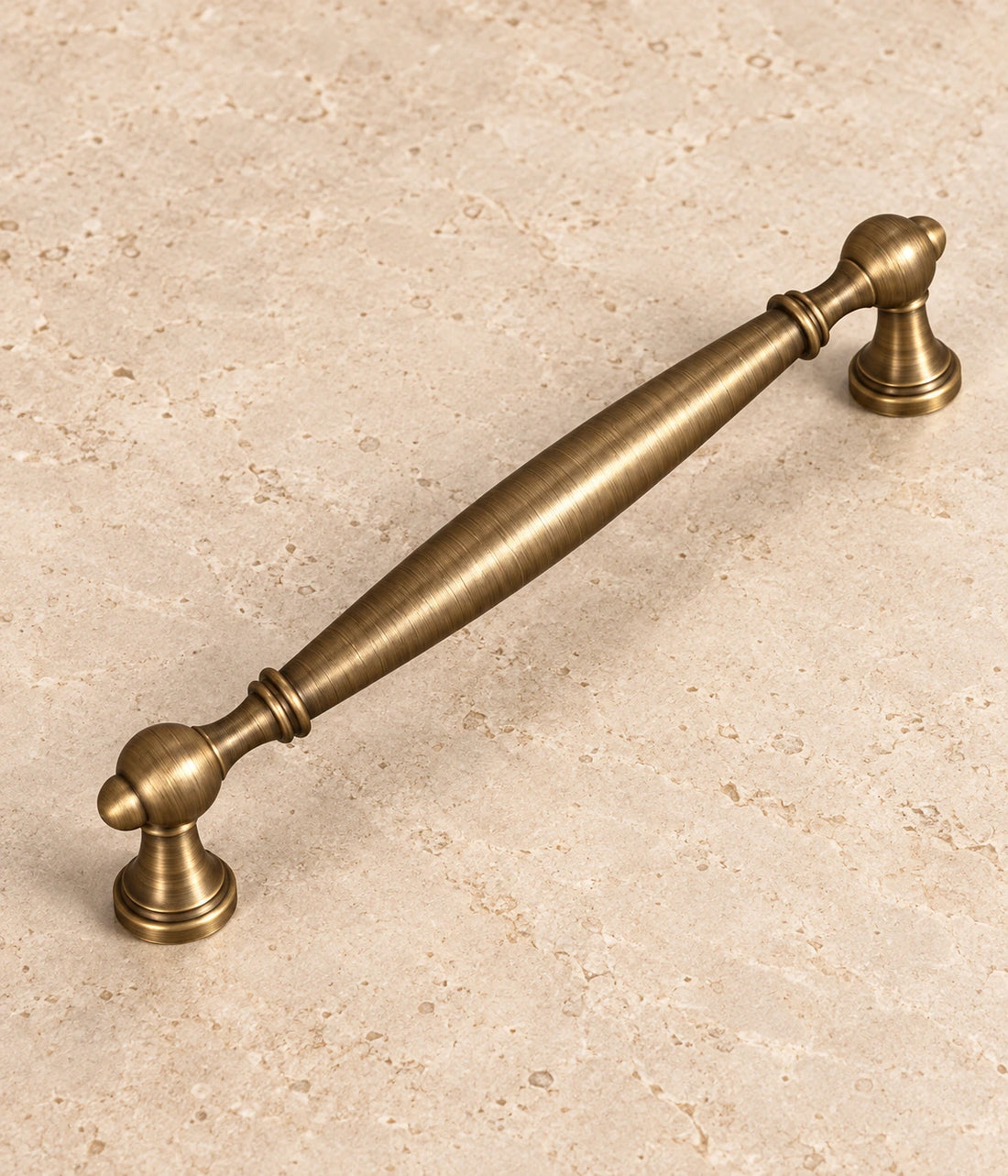 Antique Brass Smooth Spindle Cabinet Pulls on warm ivory limestone