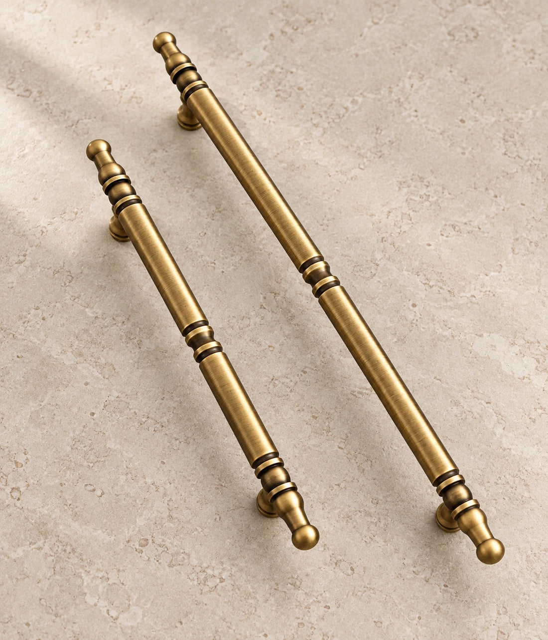 Antique Brass Spindle Cabinet Pulls on warm ivory limestone