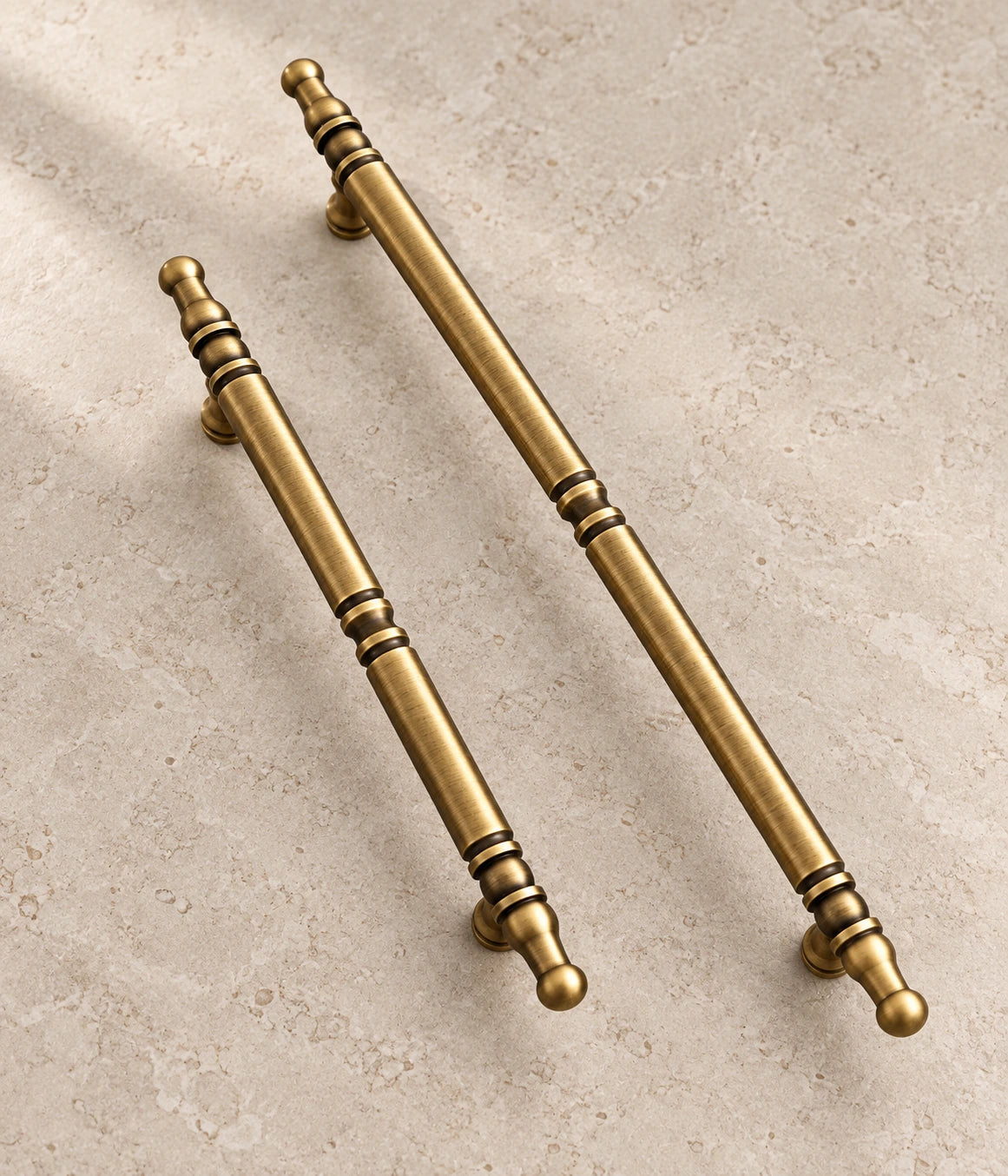 Antique Brass Spindle Cabinet Pulls on warm ivory limestone