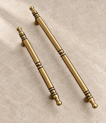 Antique Brass Spindle Cabinet Pulls on warm ivory limestone