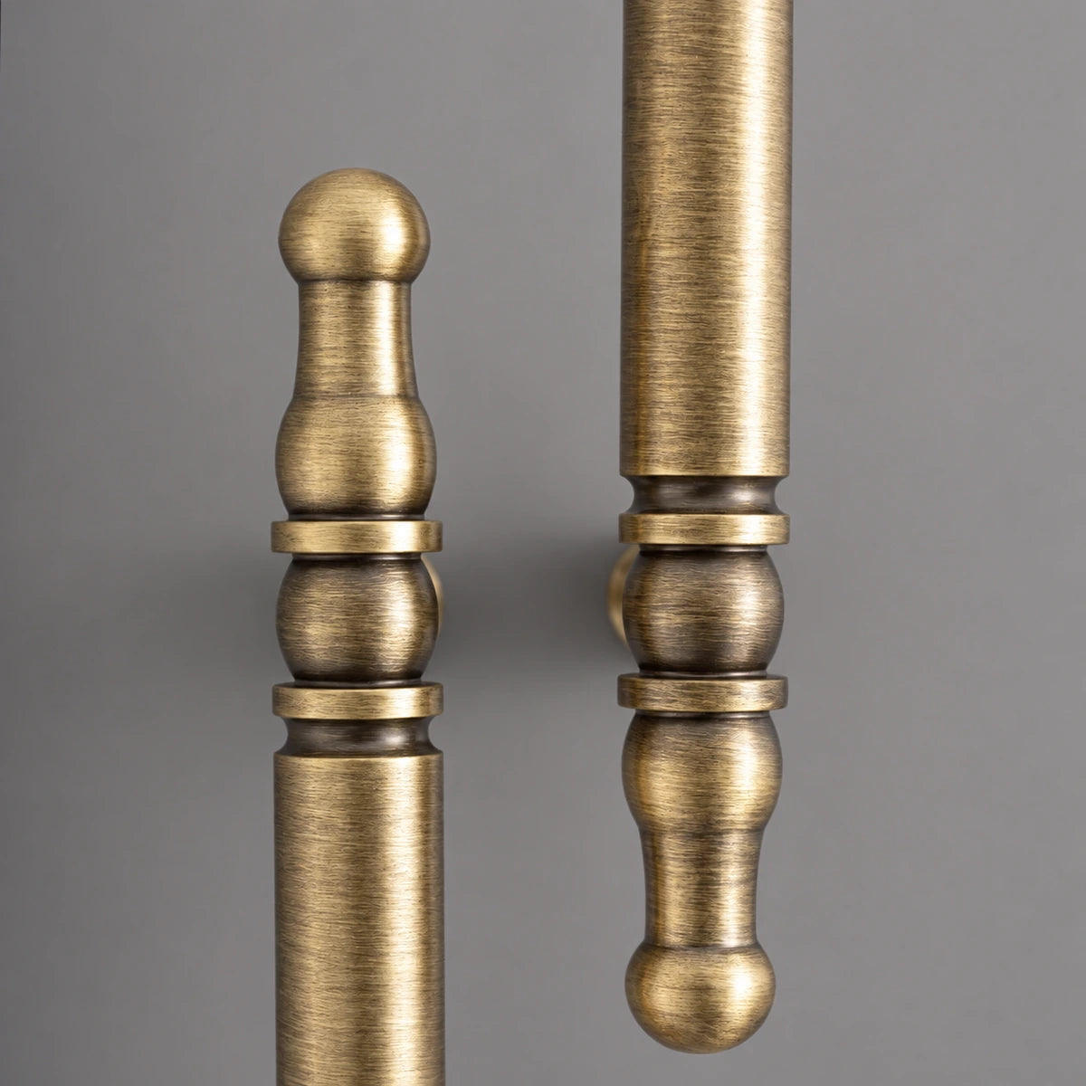 Antique brass spindle cabinet pull close-up showing brushed finish and decorative detail