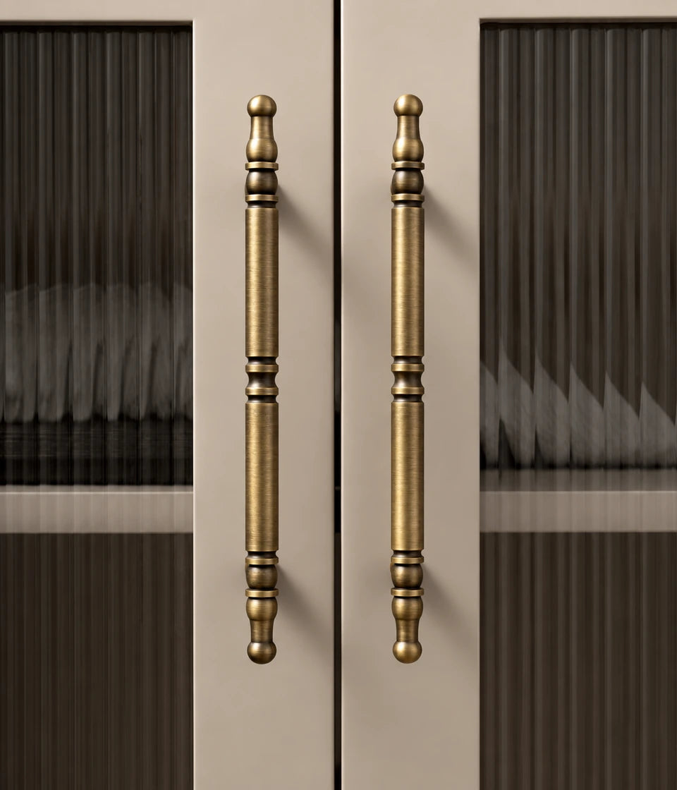 Antique brass spindle cabinet pulls installed vertically on cabinet doors