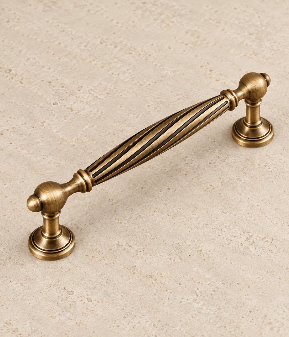 Antique Brass Spiral Cabinet Pulls & Fluted Knobs on warm ivory limestone