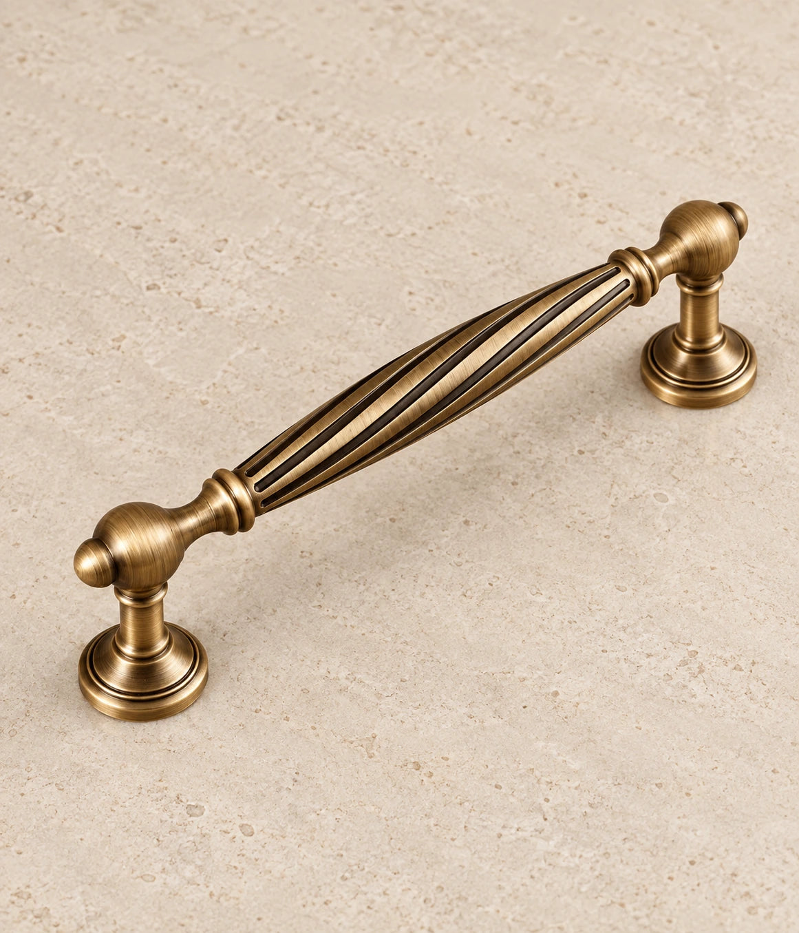 Antique Brass Spiral Cabinet Pulls & Fluted Knobs on warm ivory limestone