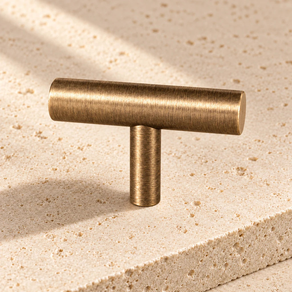 antique brass straight t bar knob limestone on pale limestone.