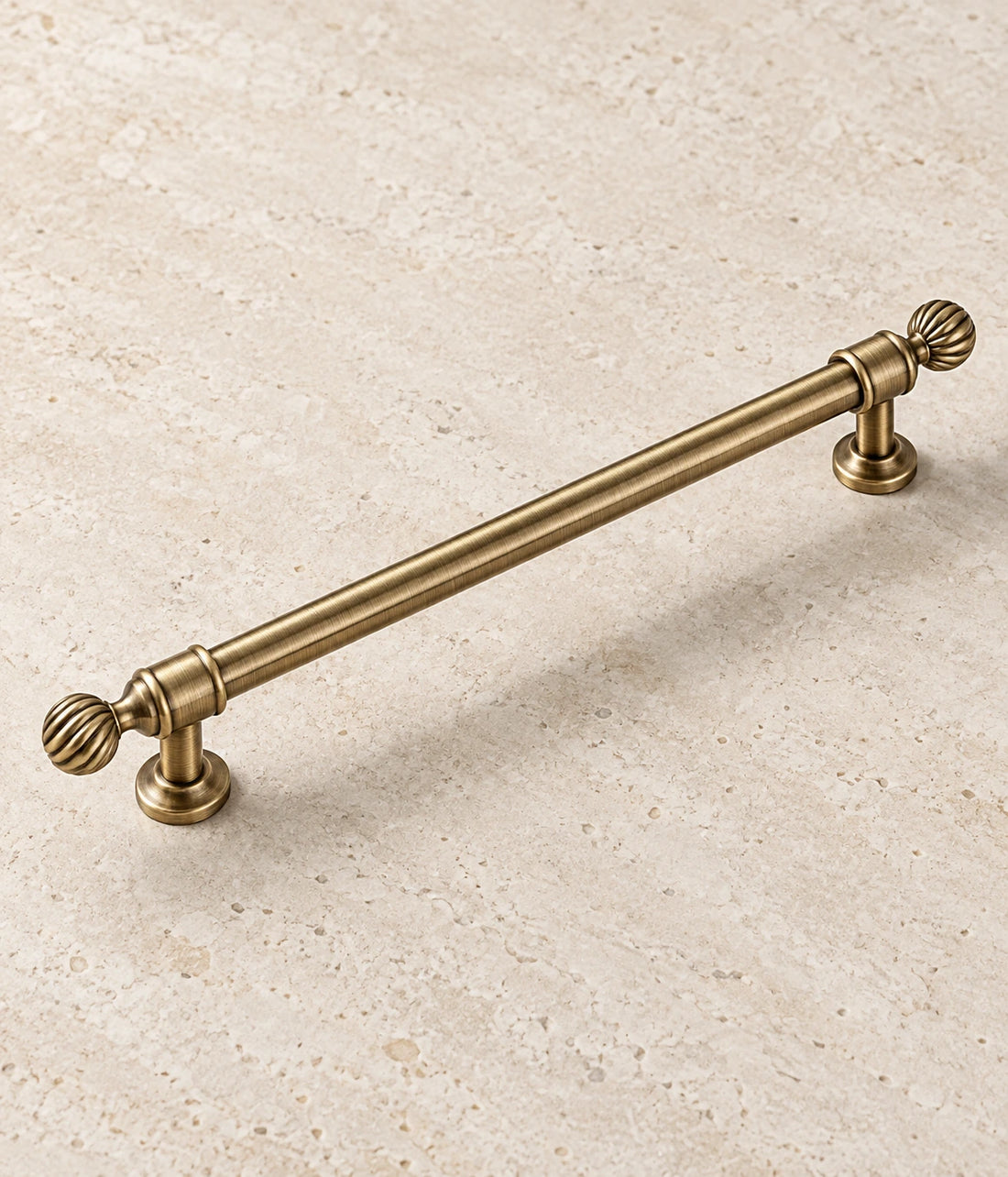 Antique Brass Swirl Finial Cabinet Pulls & Knob on warm ivory limestone