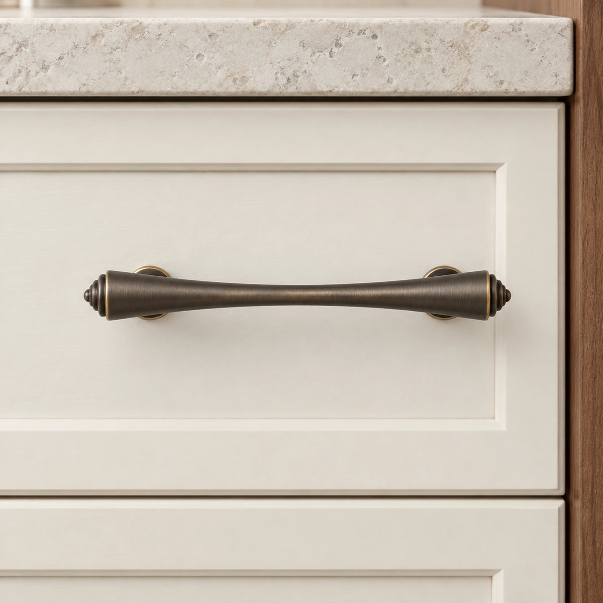 Antique brass tapered finial cabinet pull and T-knob installed on cabinet drawer fronts