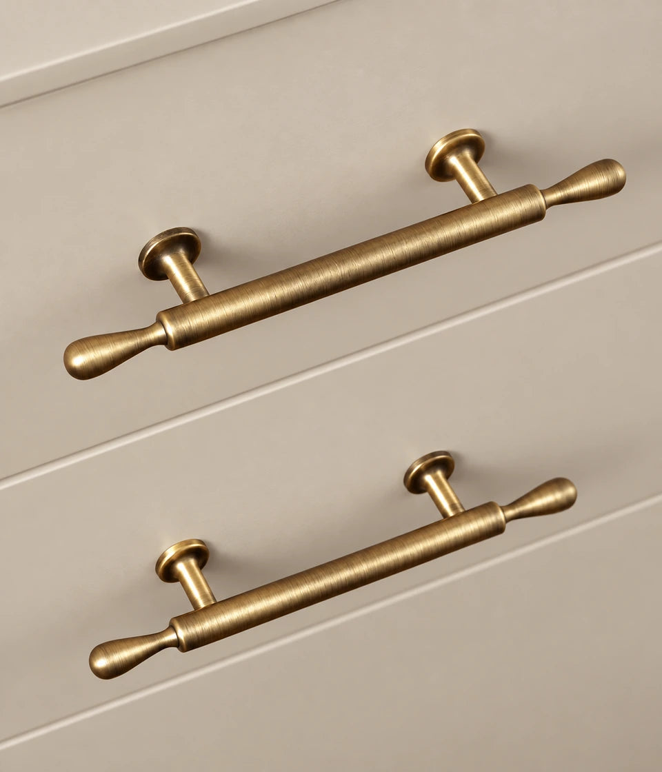 Teardrop-finial cabinet pulls installed on cream drawers