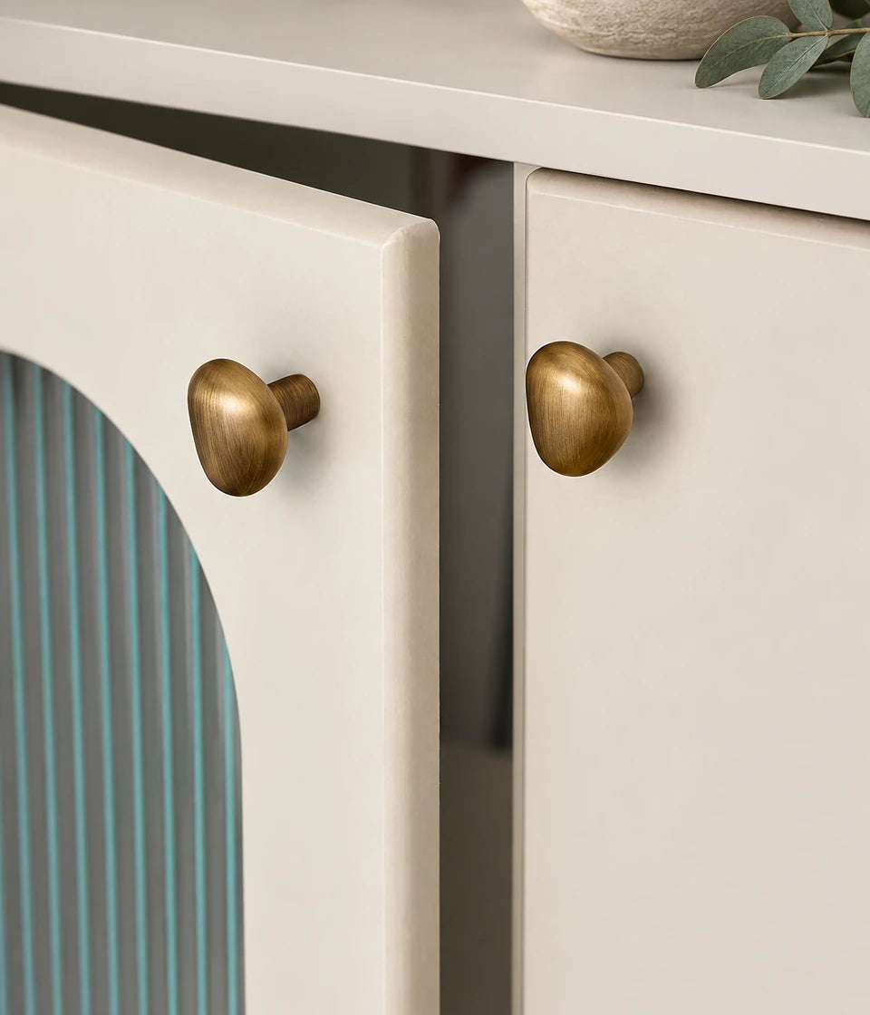 Antique brass teardrop knobs mounted on cabinet doors