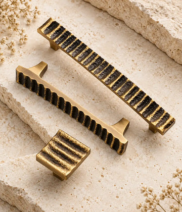 Antique brass textured wave pulls and square knob arranged on limestone