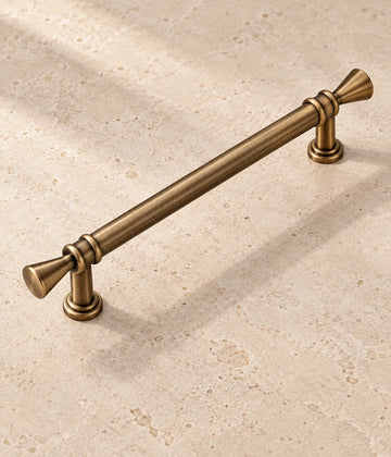 Antique Brass Trumpet Tip Cabinet Pulls & T-Knob on warm limestone