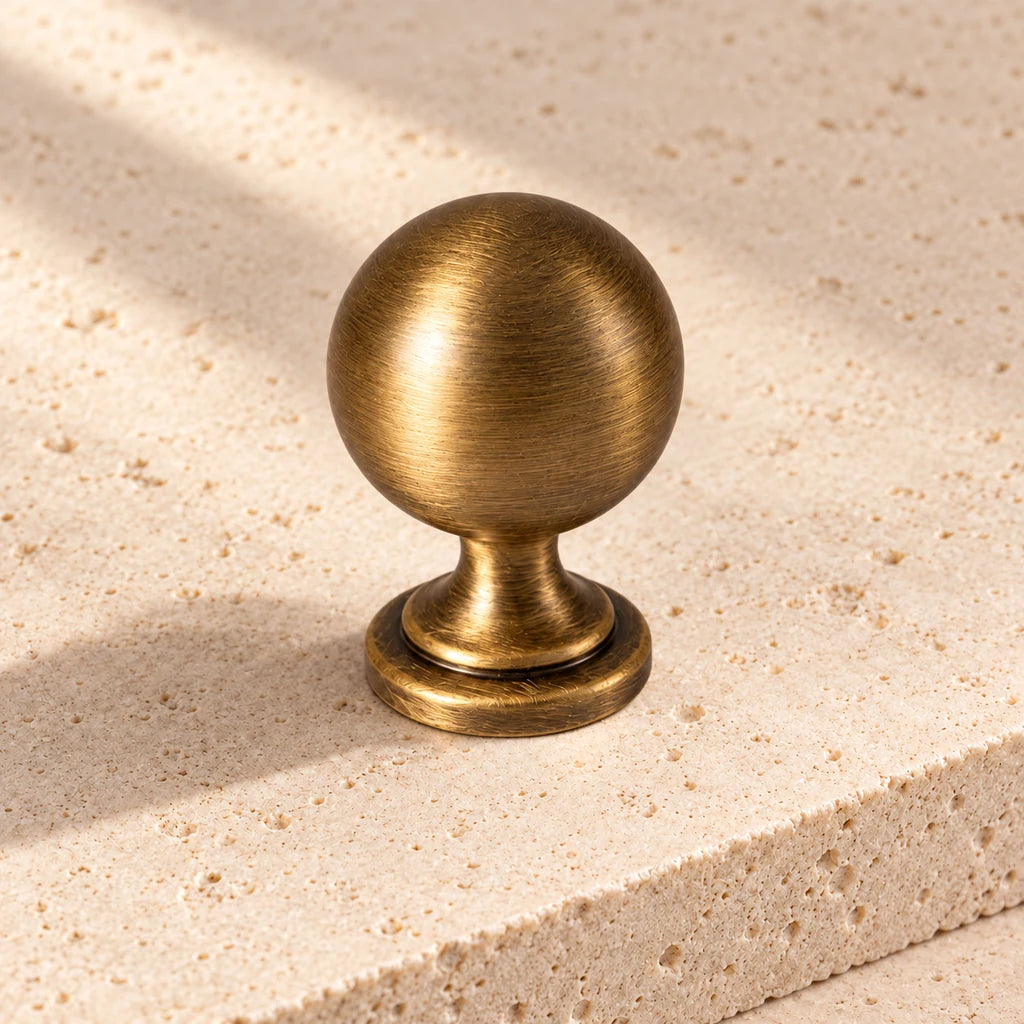 antique brass turned ball knob limestone on pale limestone.