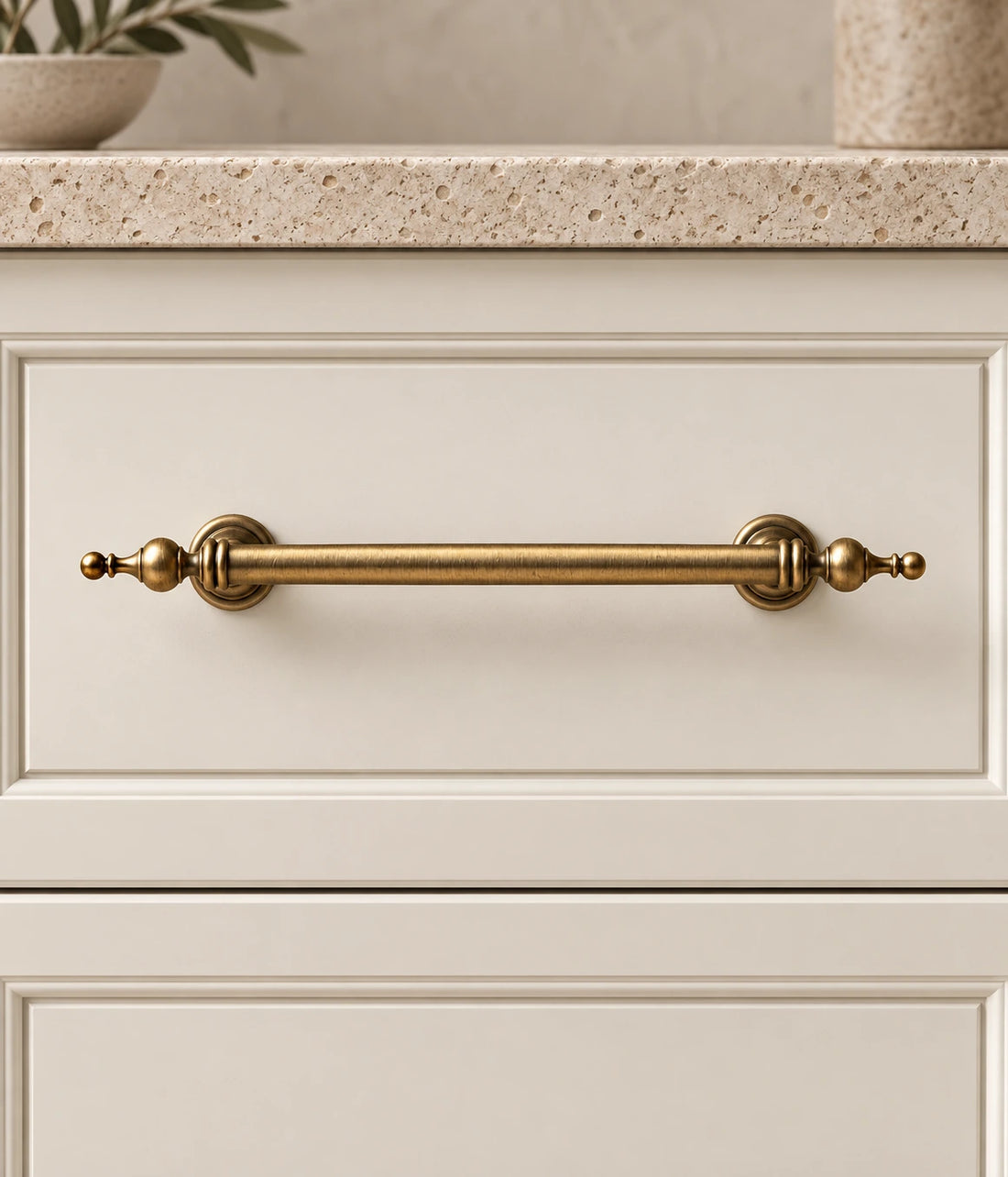 Antique brass turned-post finial cabinet pulls arranged on warm limestone with walnut background