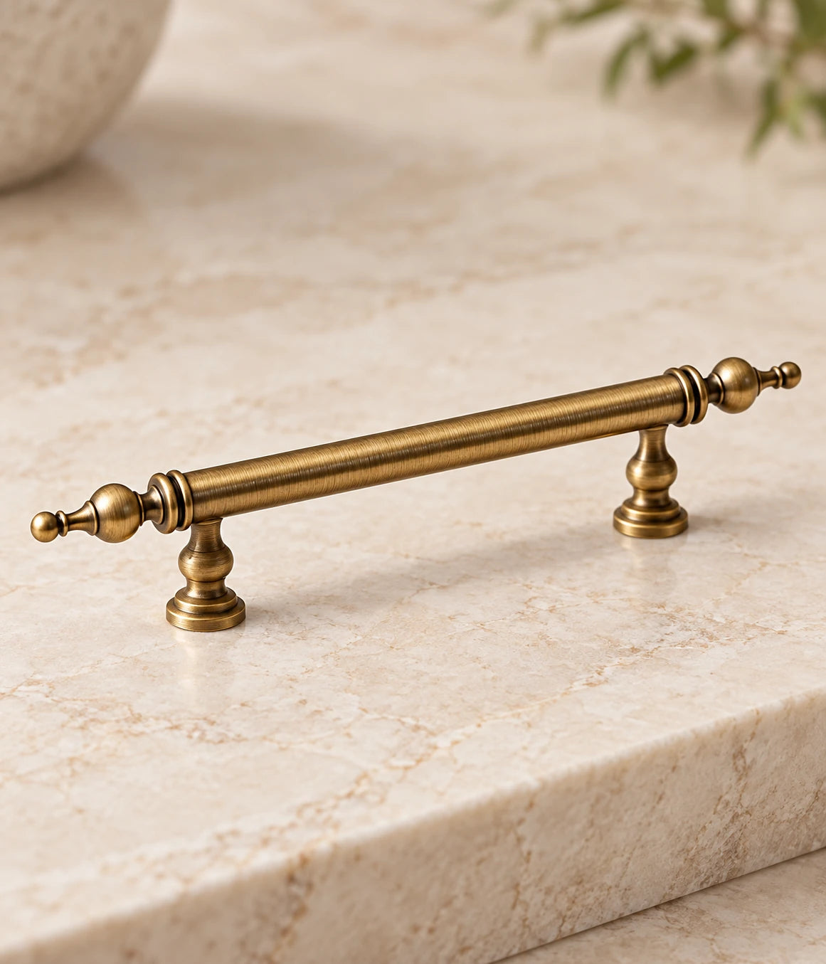 Detail of urn finial, double collar rings and turned mounting post on antique brass cabinet pull