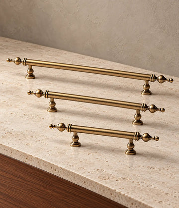 Antique brass turned-post finial cabinet pulls arranged on warm limestone with walnut background