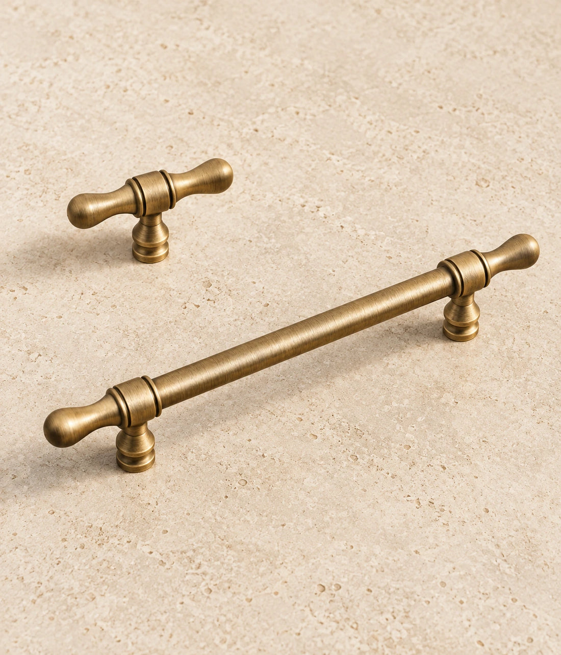 Antique Brass Turned-Tip Cabinet Pulls & T-Knob on warm ivory limestone