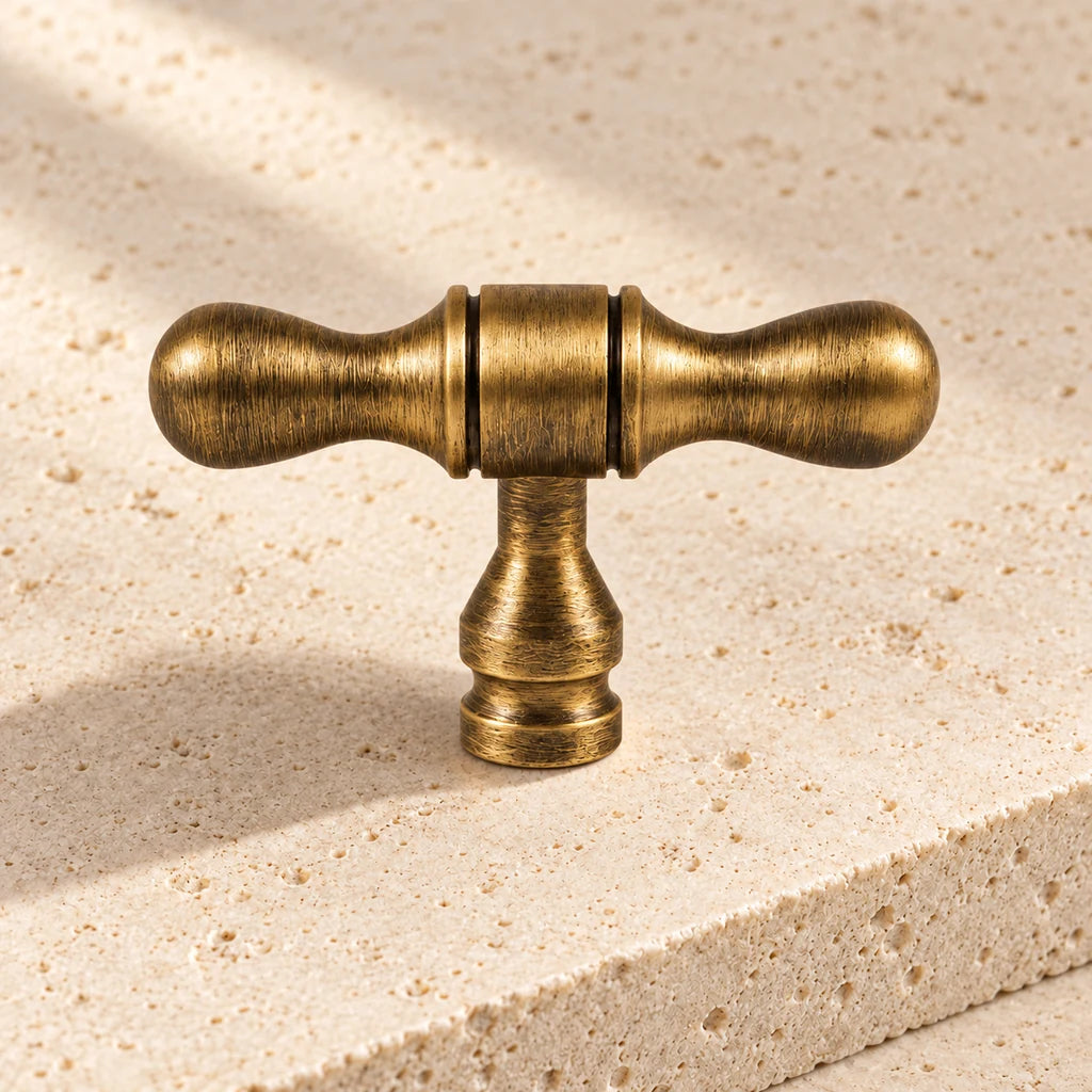 antique brass turned tip t knob limestone on pale limestone.