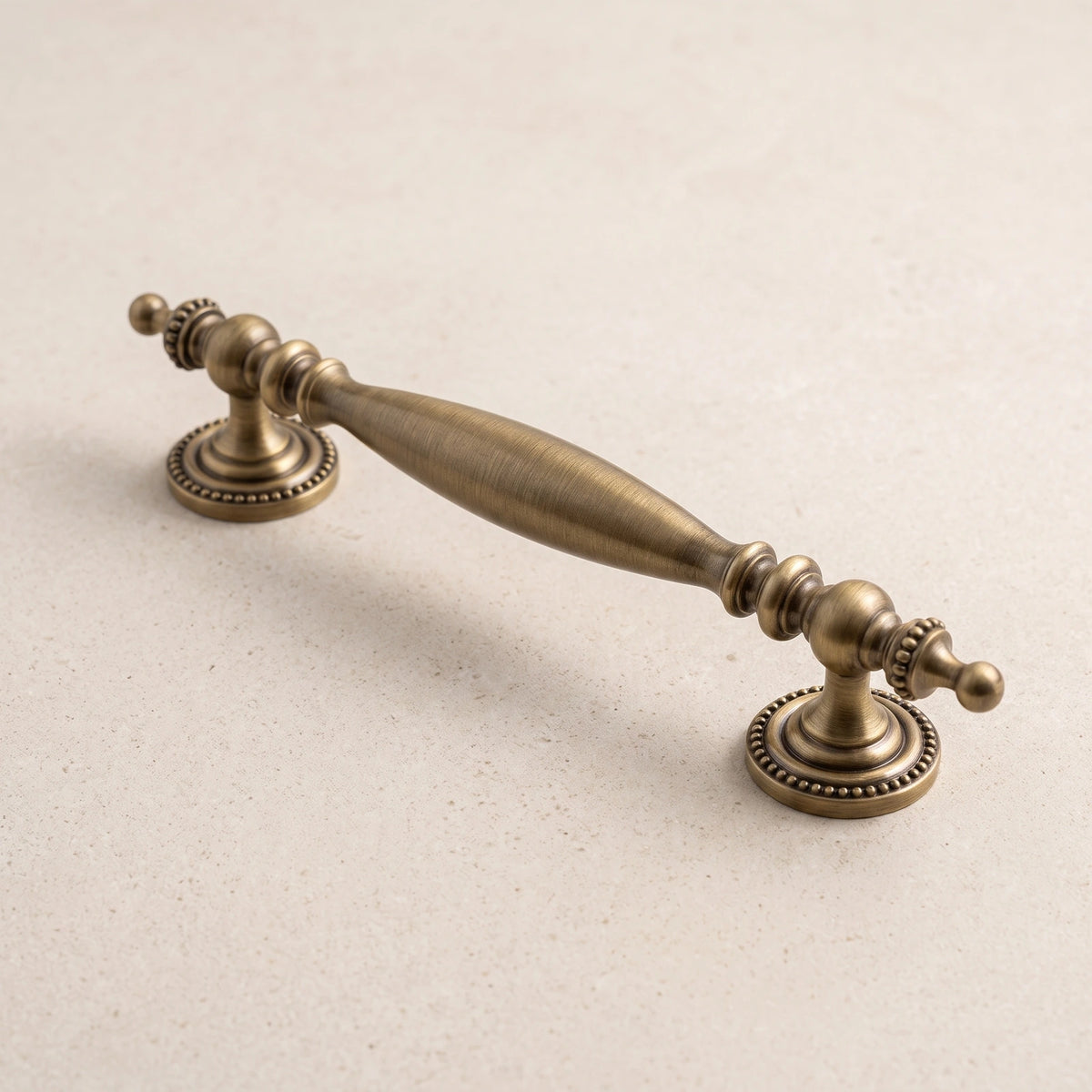 Antique brushed brass urn-end cabinet pull on limestone