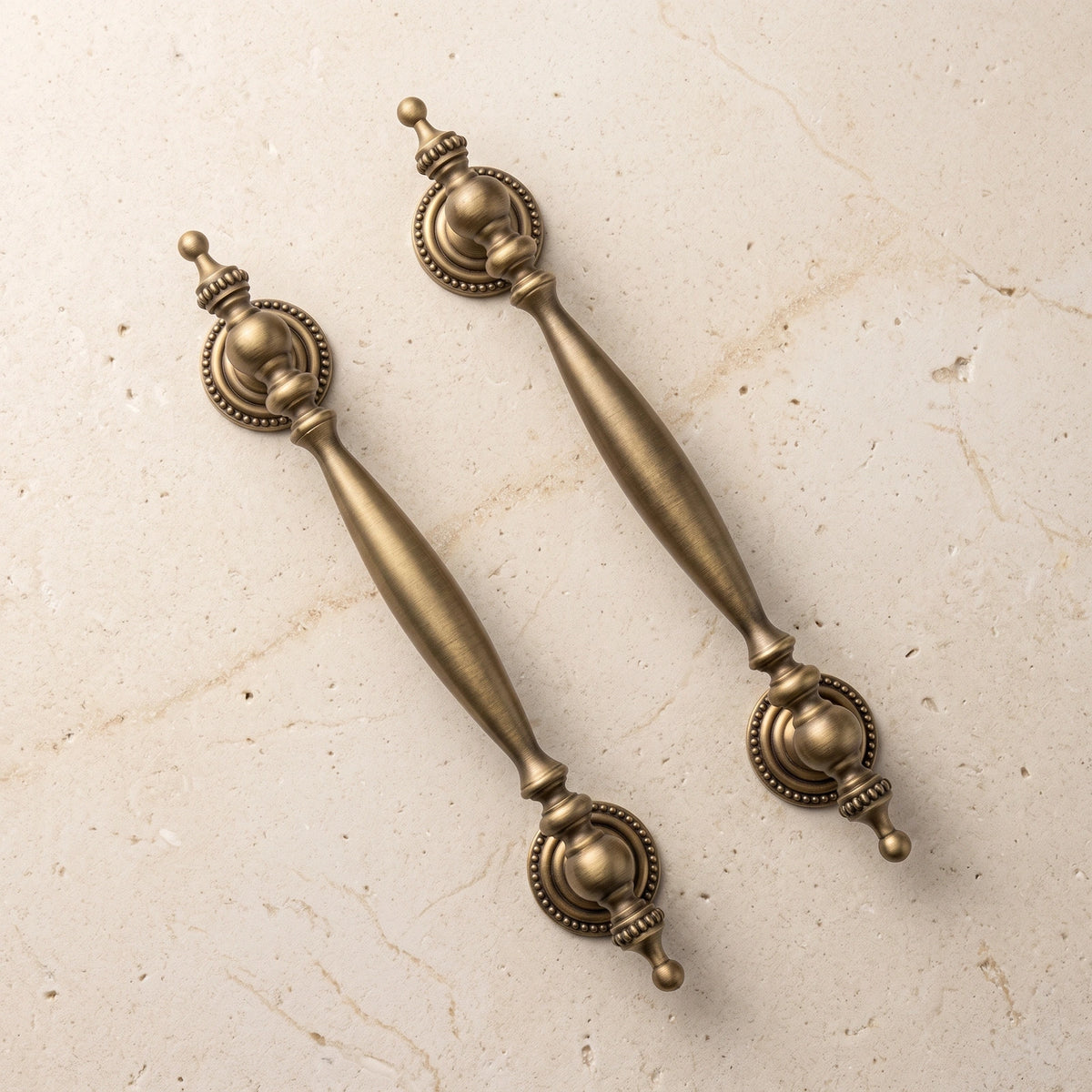 Antique brass urn-end cabinet pulls in two sizes on premium limestone