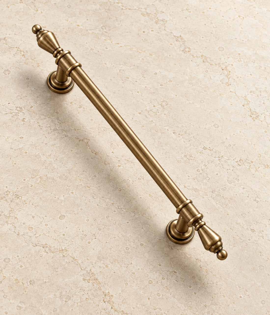 Antique Brass Urn-Finial Cabinet Pulls on warm ivory limestone