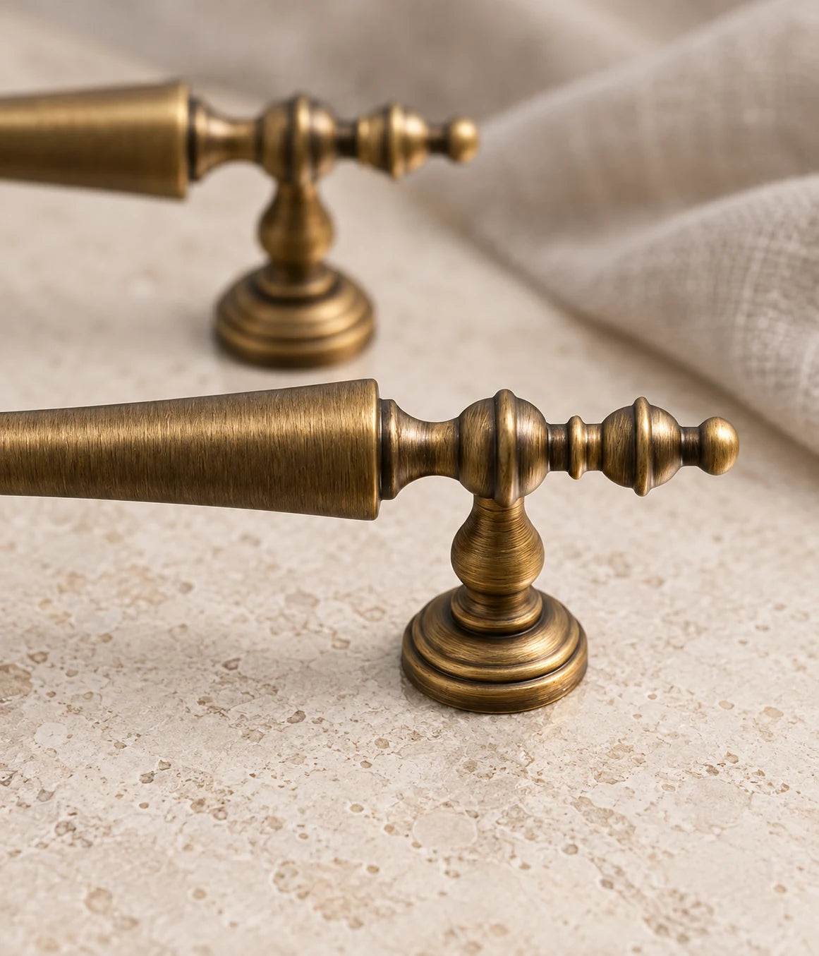 Turned finial and stepped mounting foot on an antique brass cabinet pull