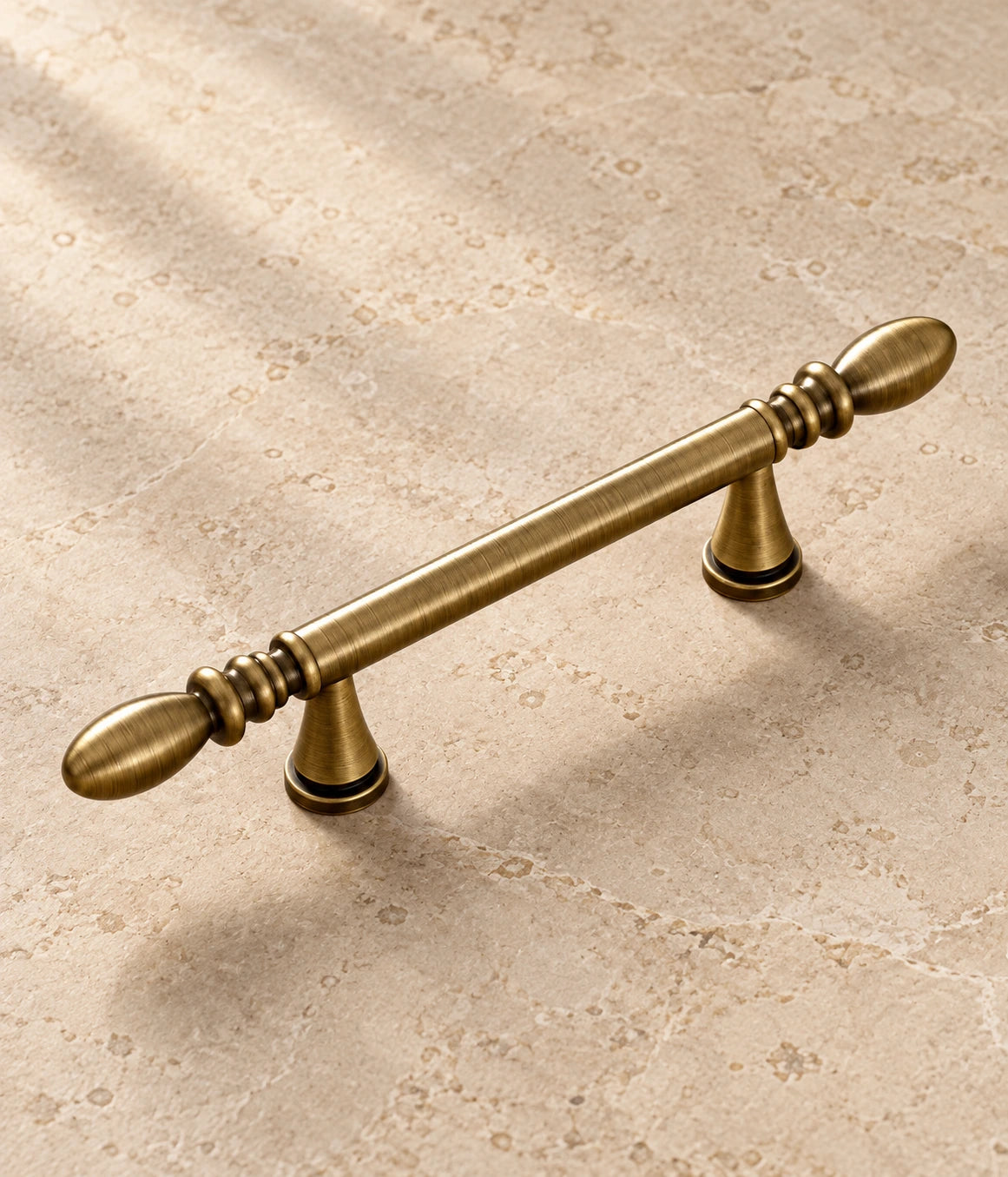 Antique Brass Water-Drop Cabinet Pulls on warm ivory limestone