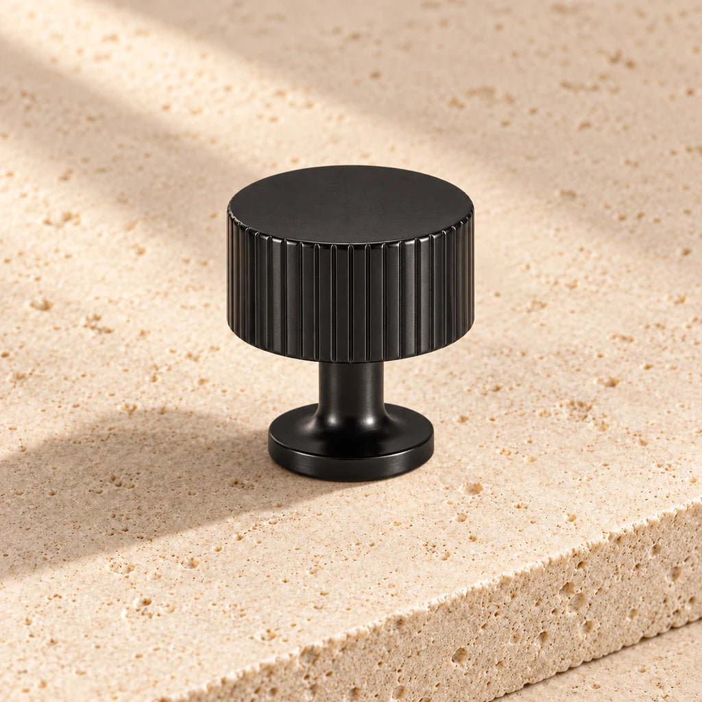 black art deco cabinet knob on pale limestone.