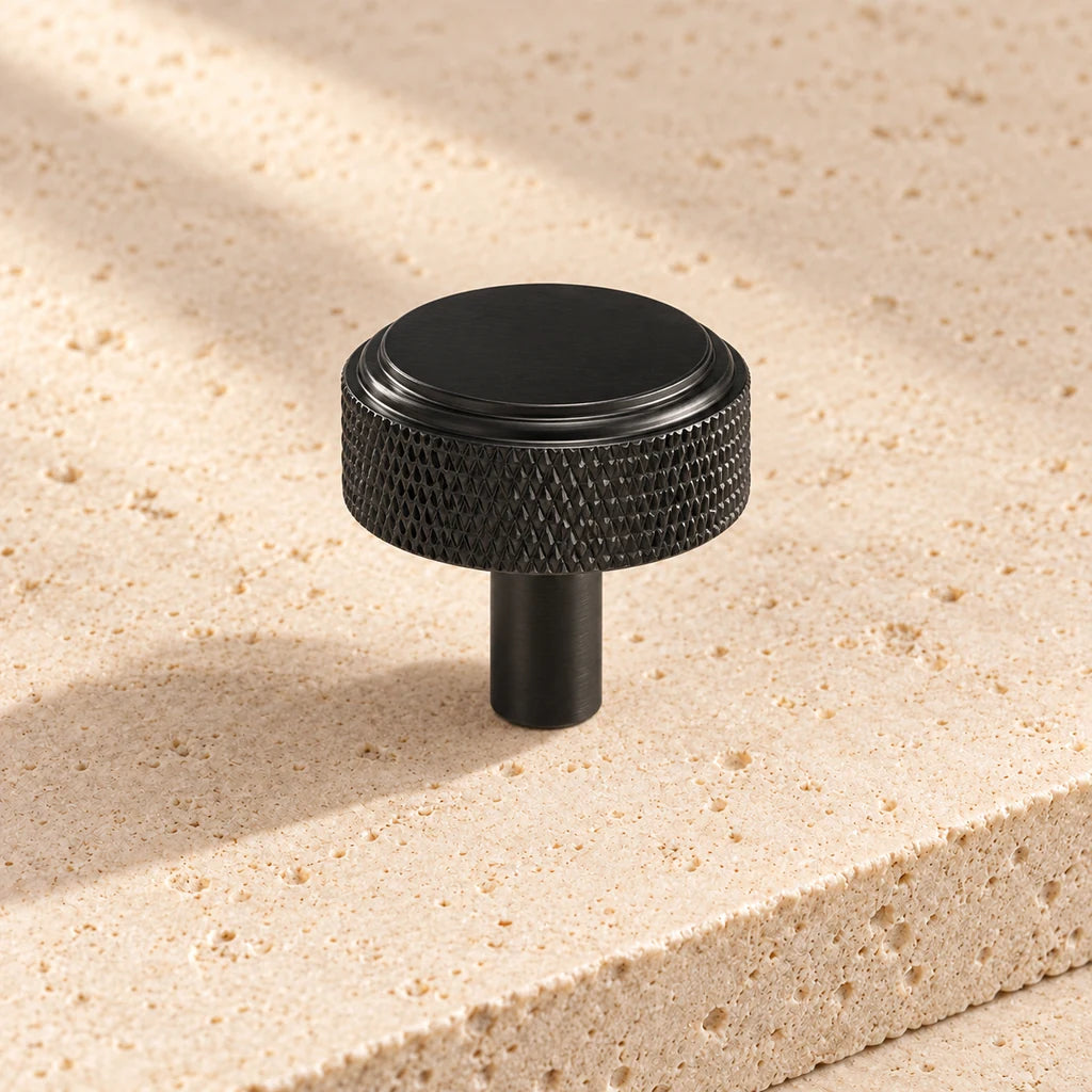 black diamond cut round knob on pale limestone.
