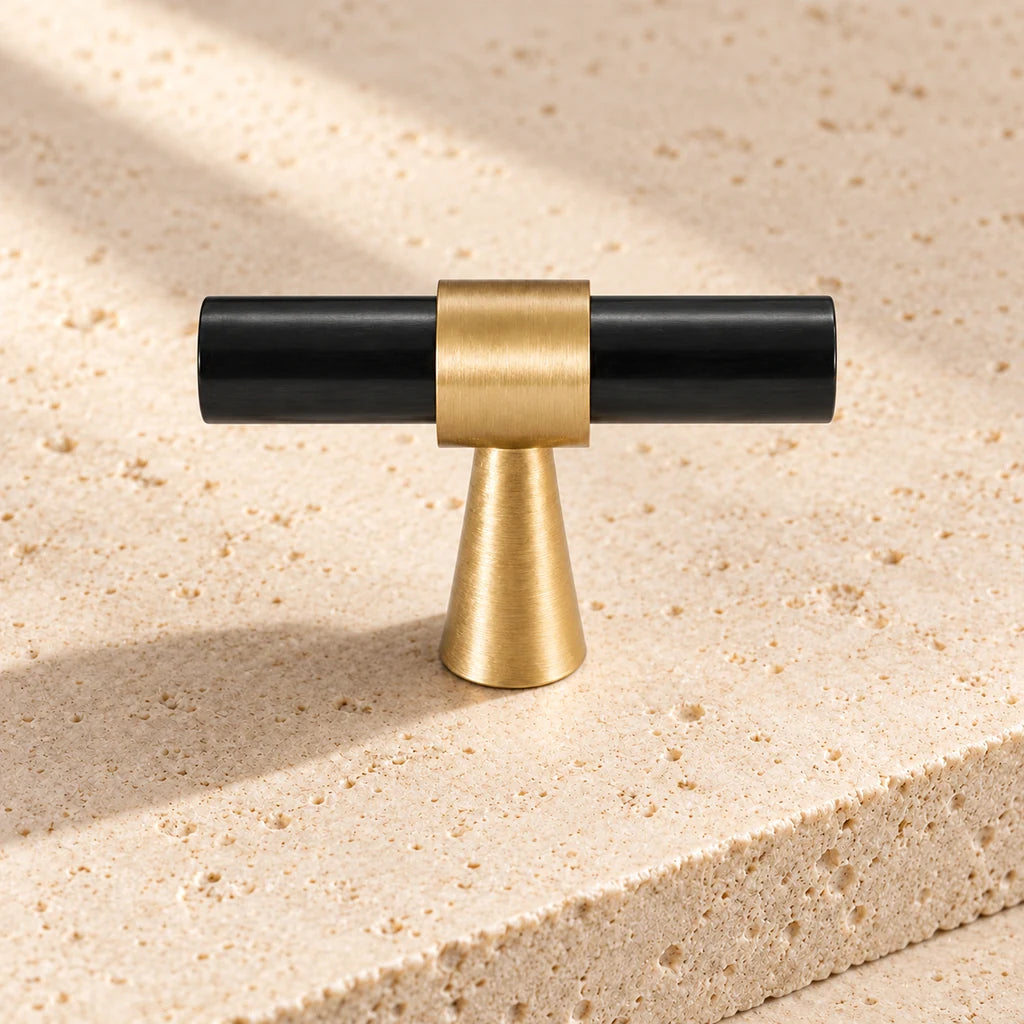 black gold brass stepped ring t knob on pale limestone.