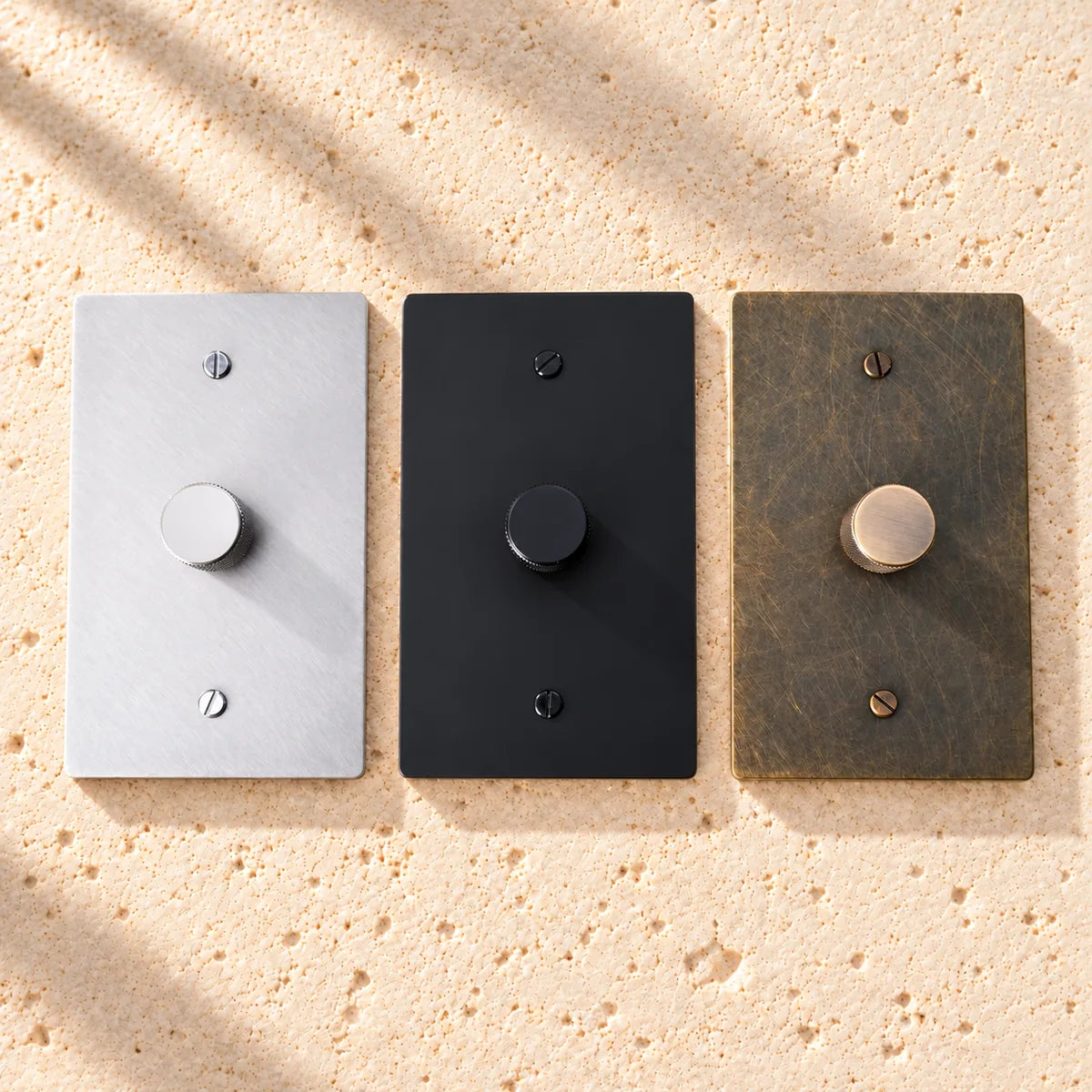 Three wall light switches in white, black, and wood finish on a white background