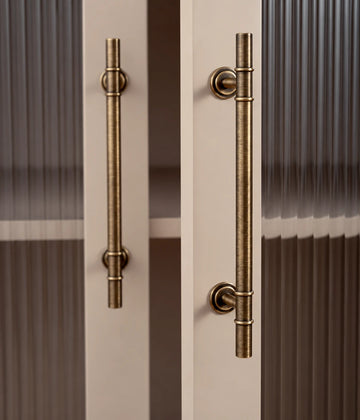 Antique brass double collar cabinet bar pulls installed on fluted glass doors