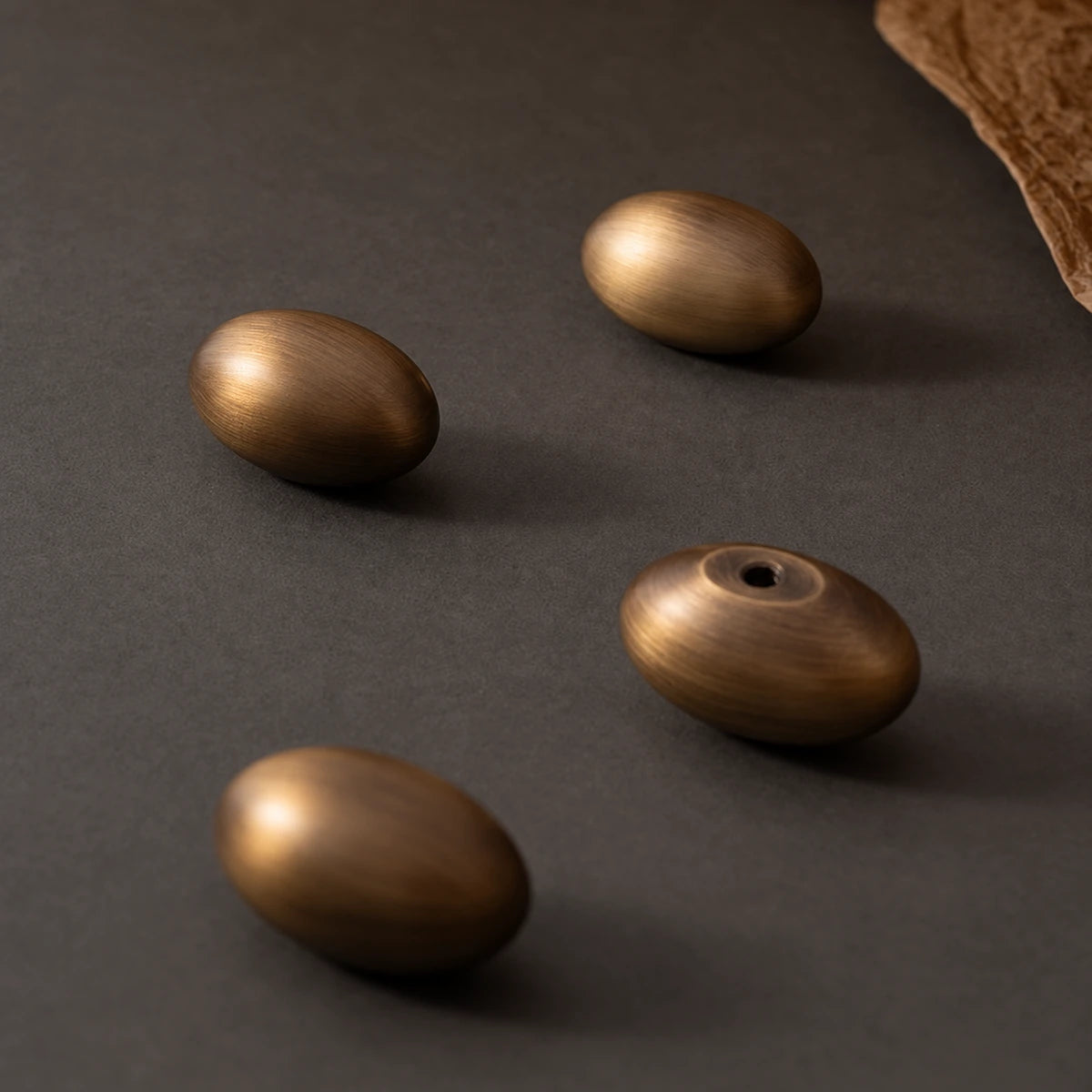 Stemless brass egg knobs showing rounded grip and rear mounting hole