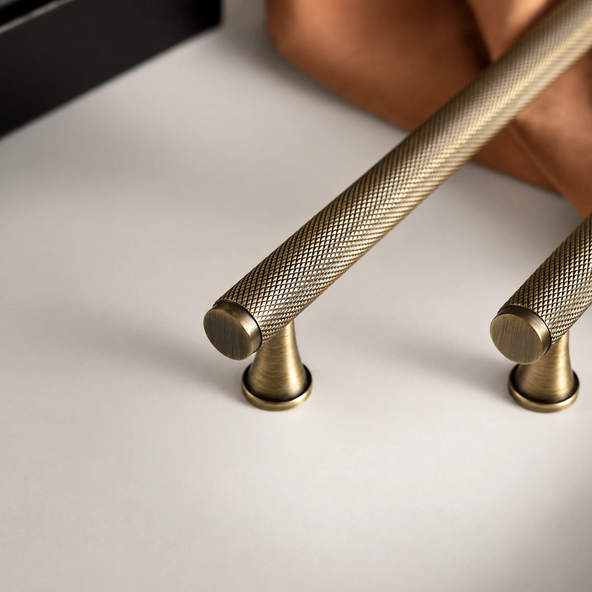 Close-up of diamond-knurled antique brass cabinet pull grip