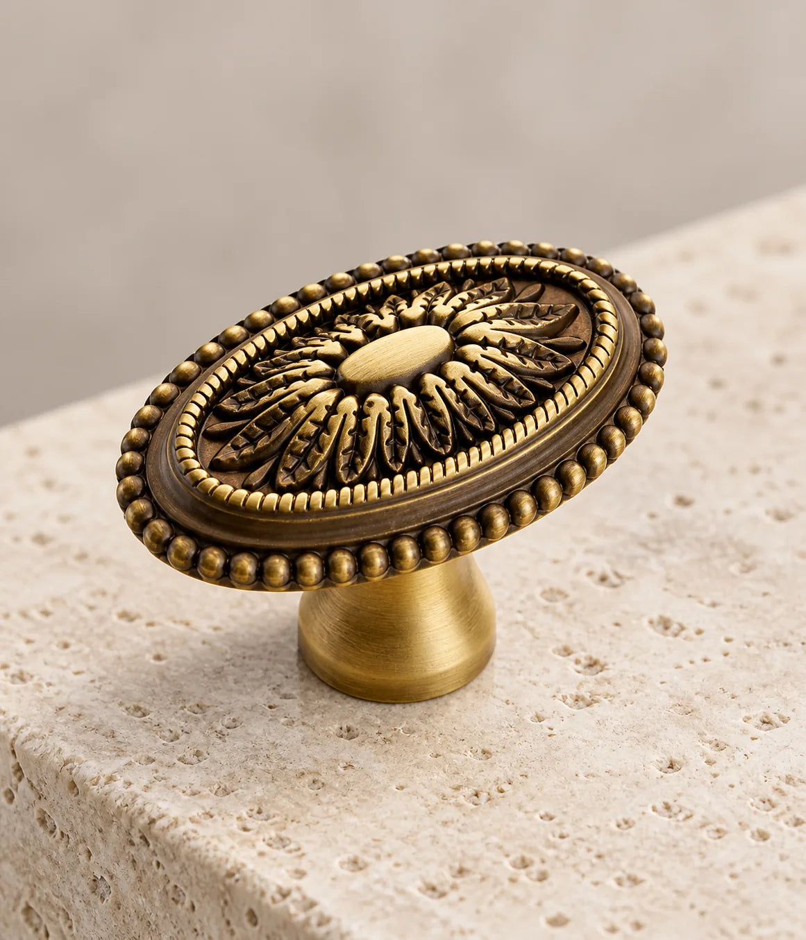 Close-up of raised acanthus leaves and beaded rim on the antique brass cabinet knob