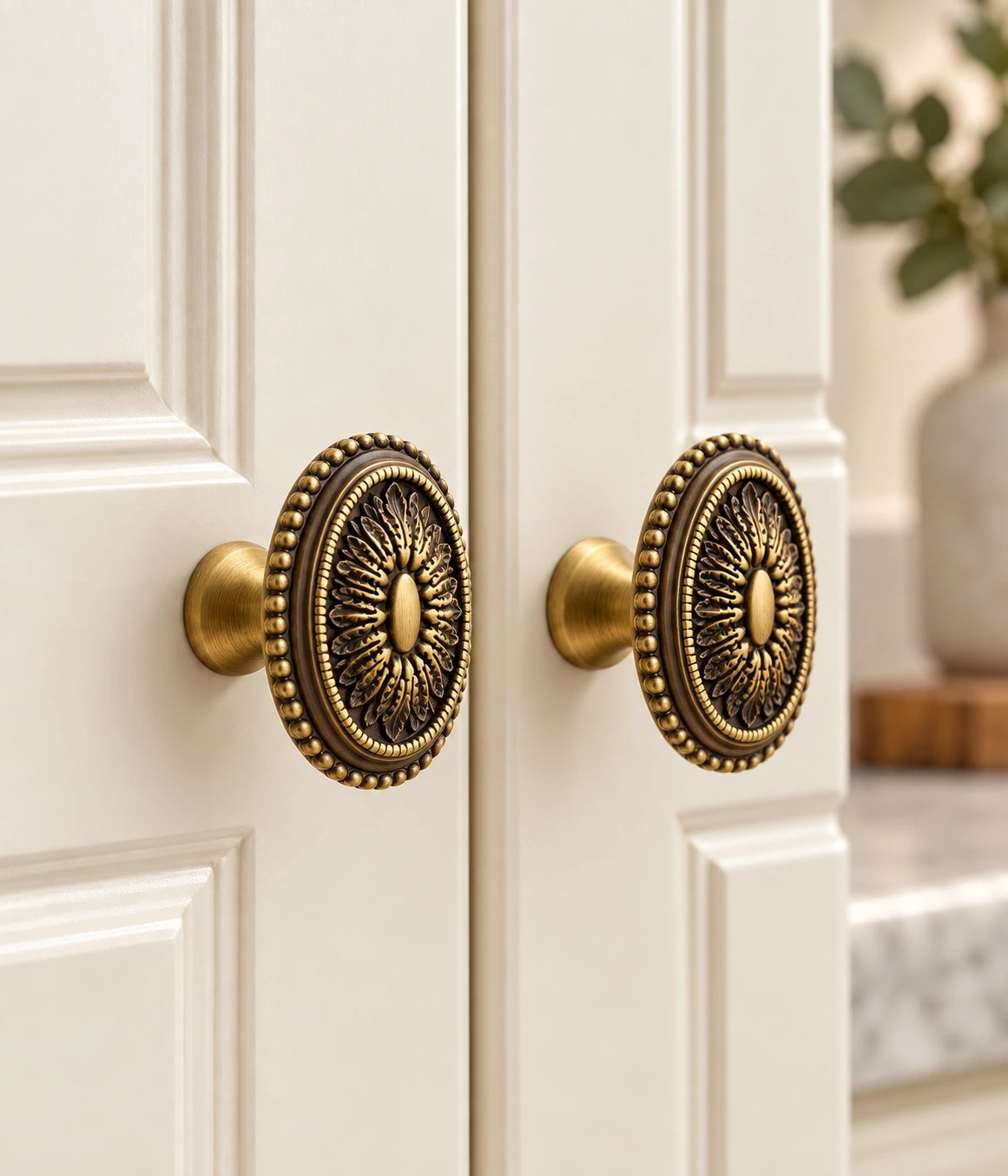 Antique brass acanthus medallion knobs fitted to cream cupboard doors