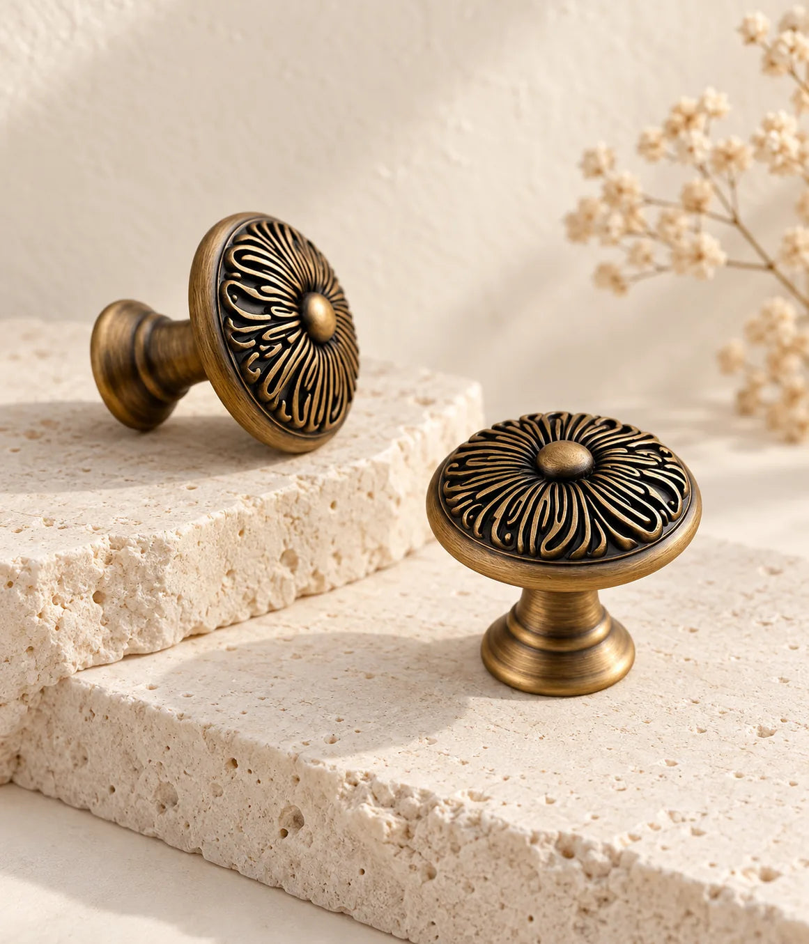 Antique brass chrysanthemum cabinet knobs arranged on pale stone ledges