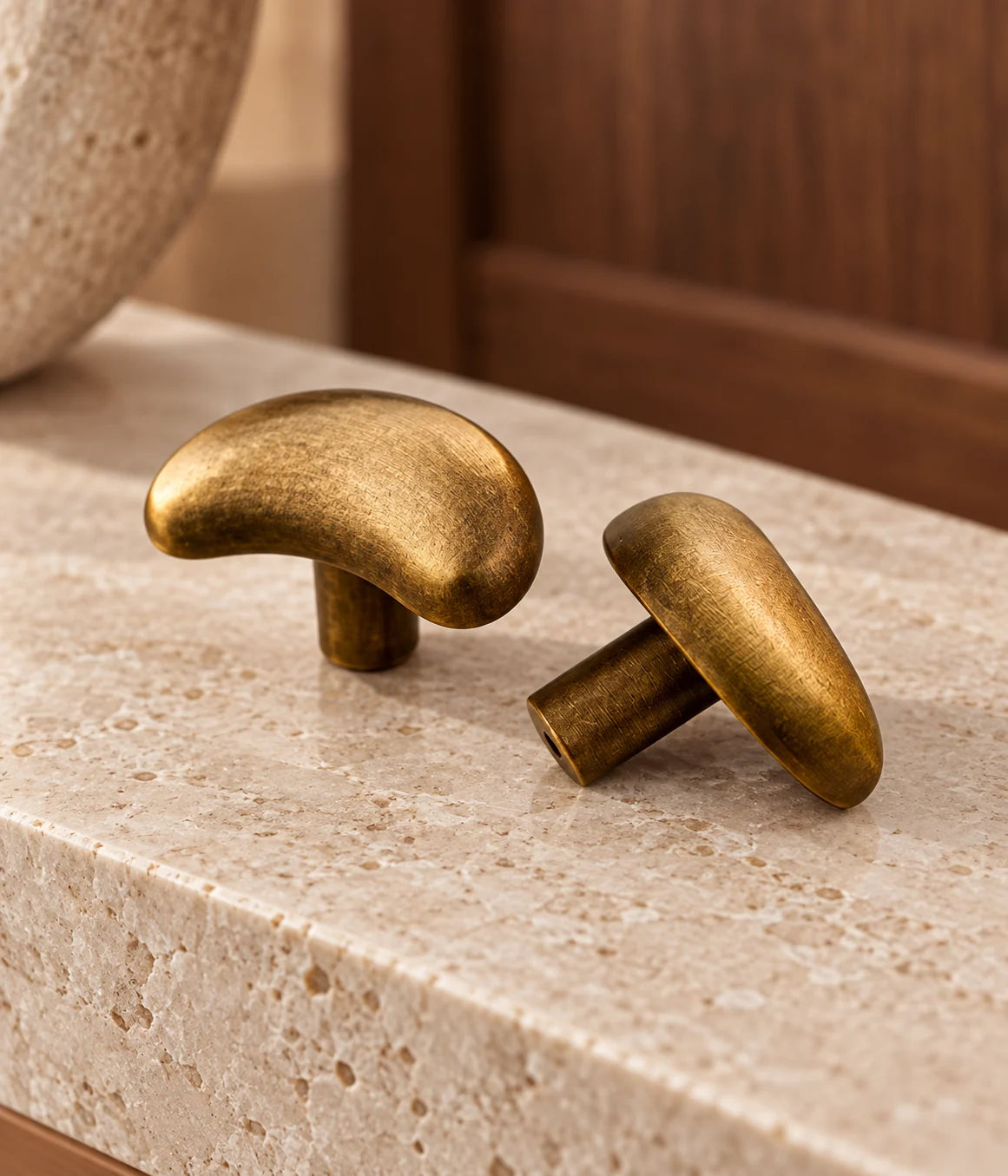 Crescent knobs showing front and stem beside walnut cabinetry