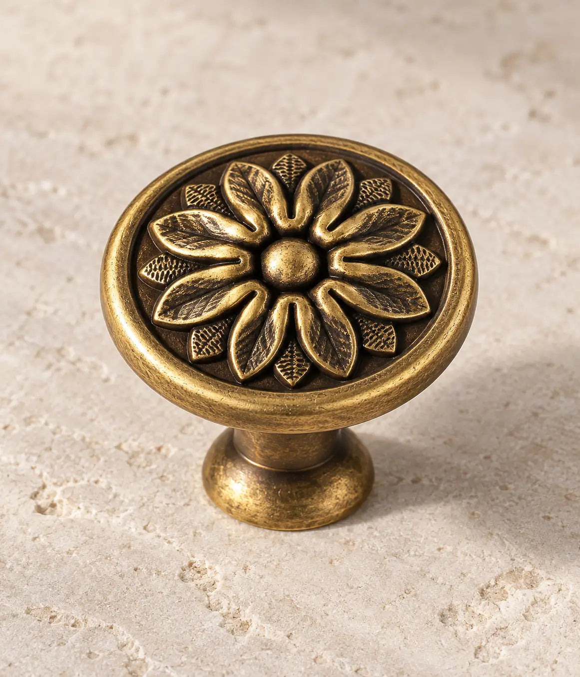 Close-up of raised flower petals and smooth rim on antique brass floral disc knob