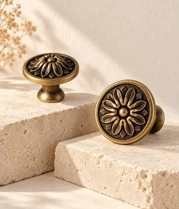 Antique brass floral disc cabinet knobs on ivory limestone showing both face sizes
